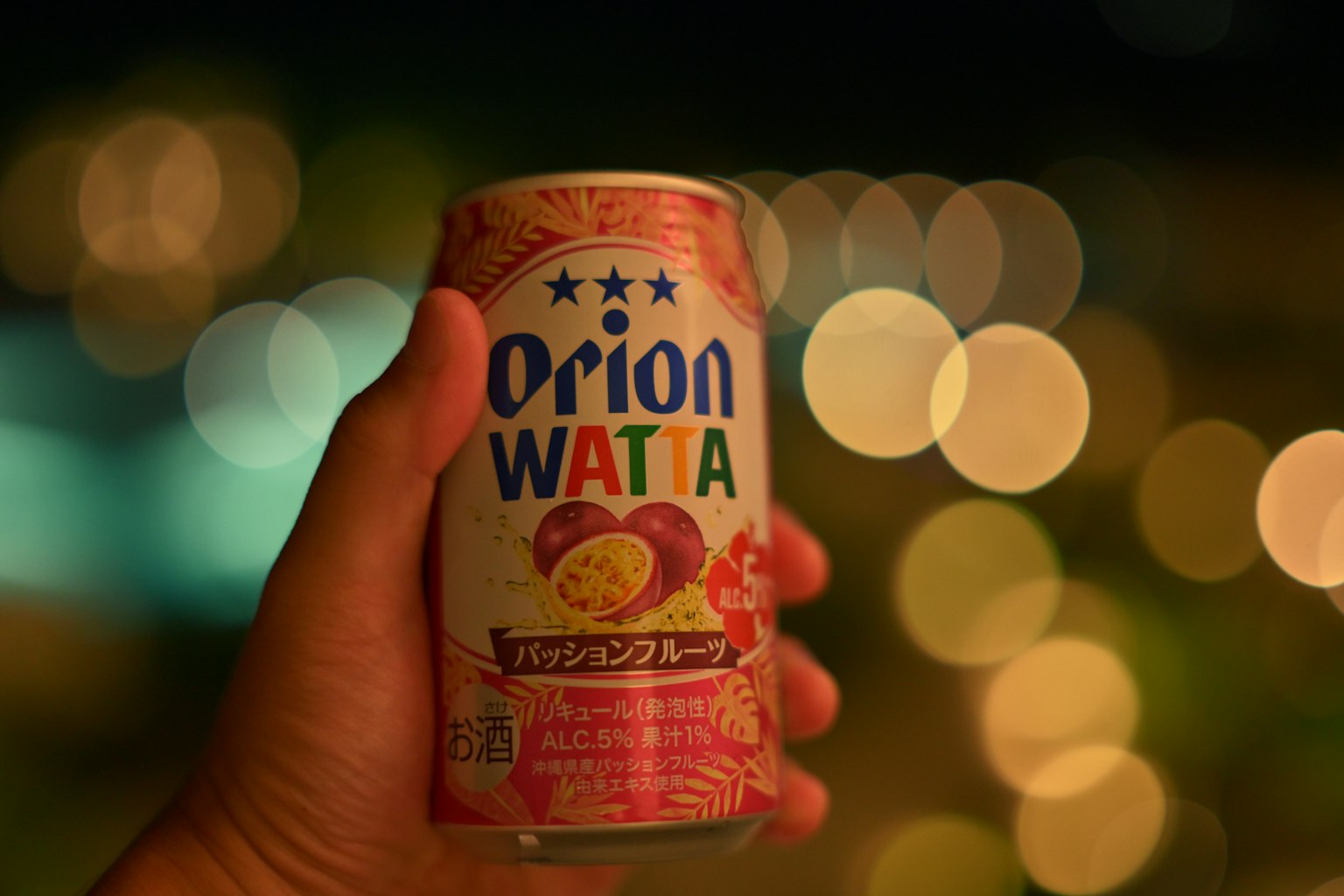 手握着一罐Orion WATTA，背景模糊美丽