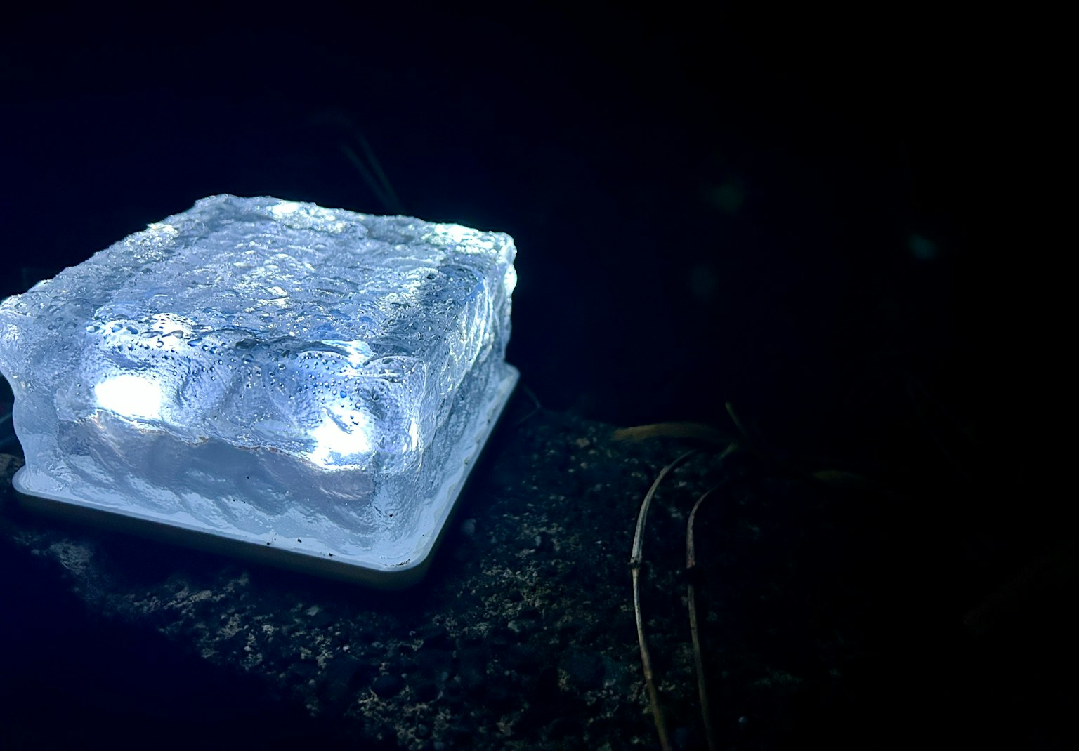 Beleuchteter Eisblock vor dunklem Hintergrund