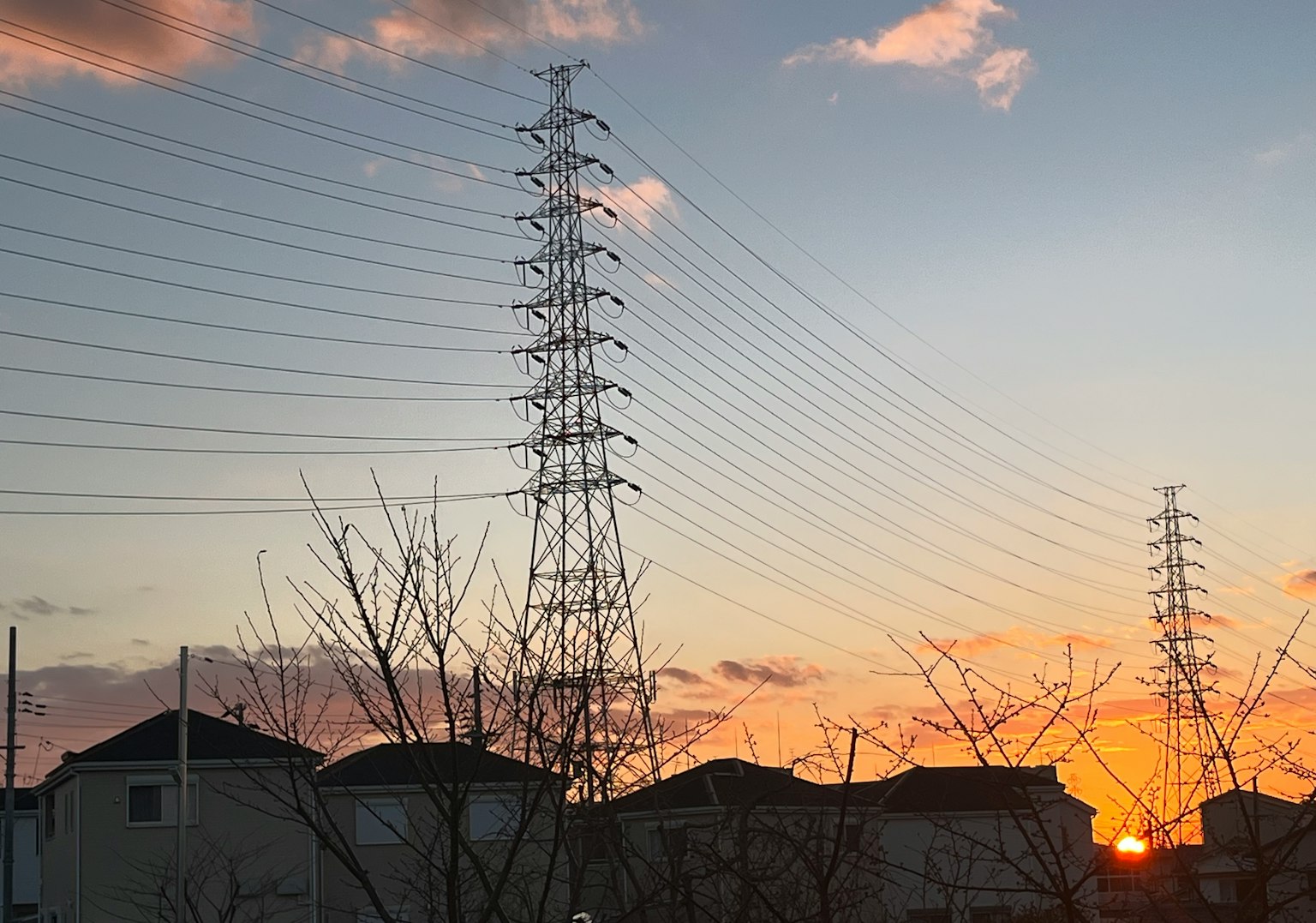 日落时电线和房屋的轮廓