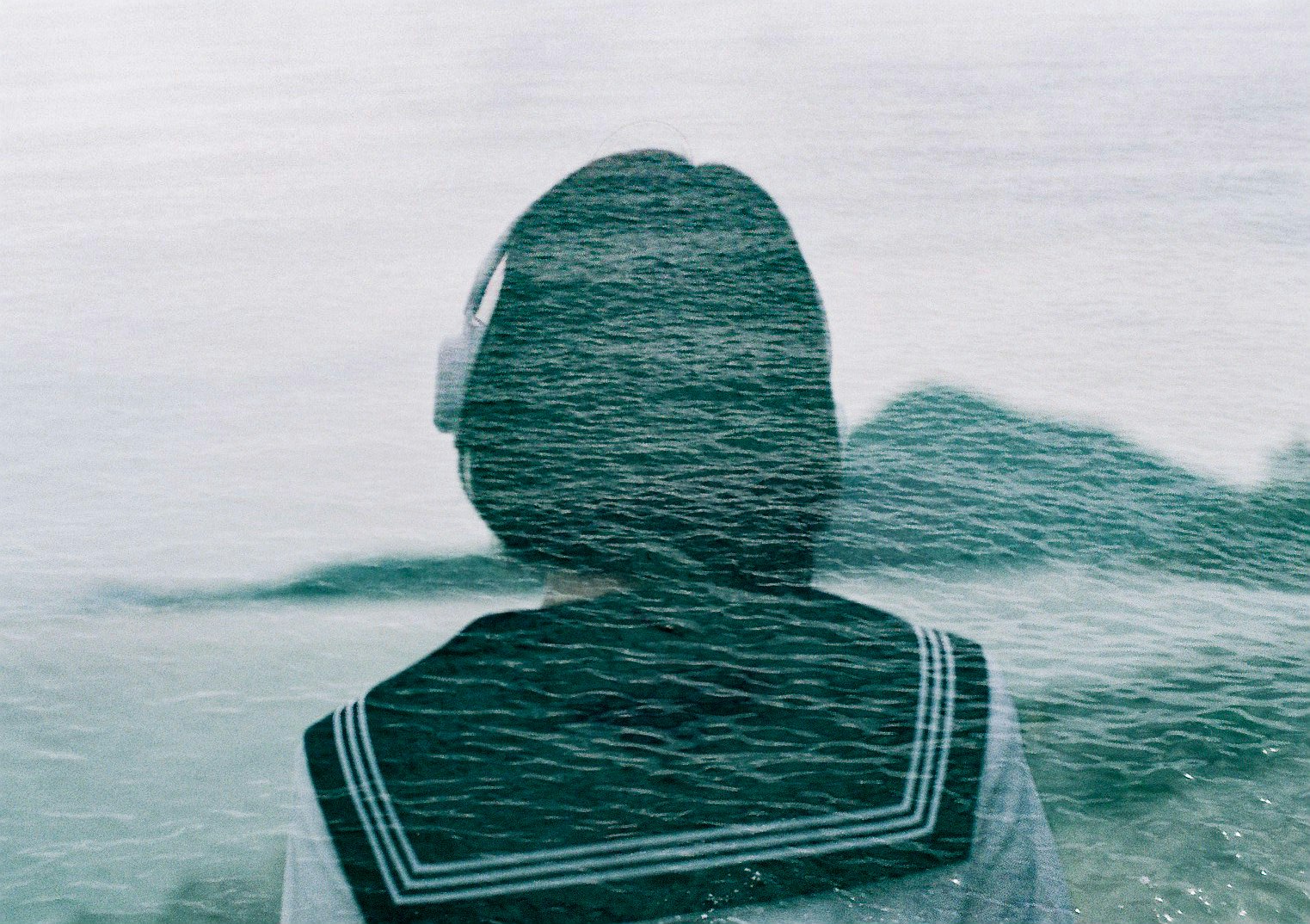 a person floating in the sea, seen from behind