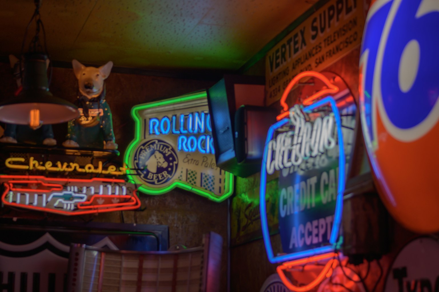 Interior de un bar con letreros de neón coloridos que presentan una mascota Chihuahua y un letrero de Rolling Rock