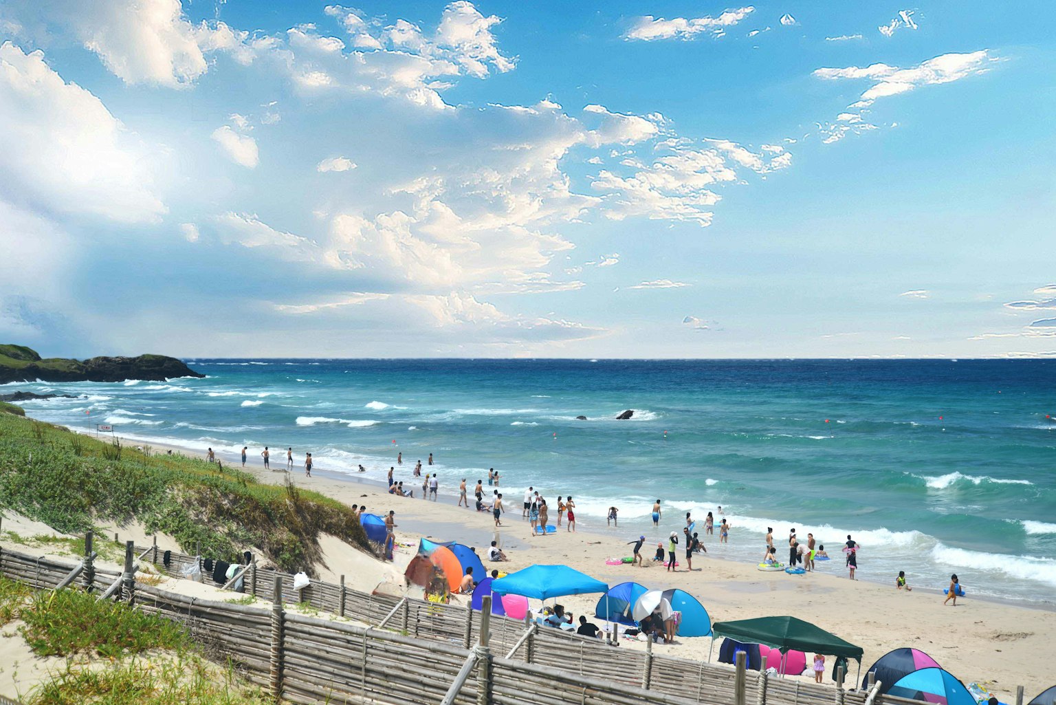 Scena di spiaggia con oceano blu e sabbia bianca con molte persone e ombrelloni colorati