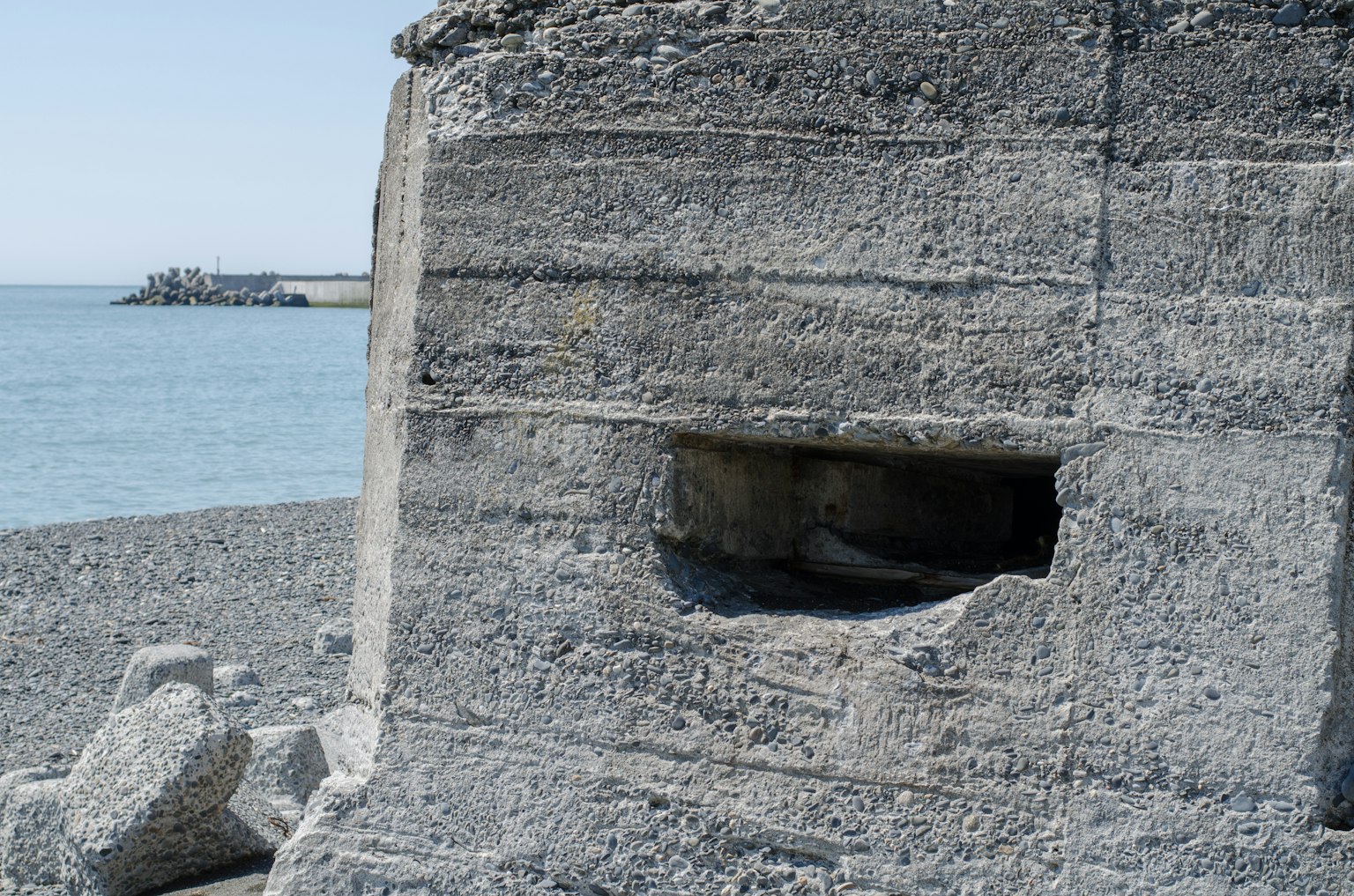 A window-like opening in a rocky wall facing the sea