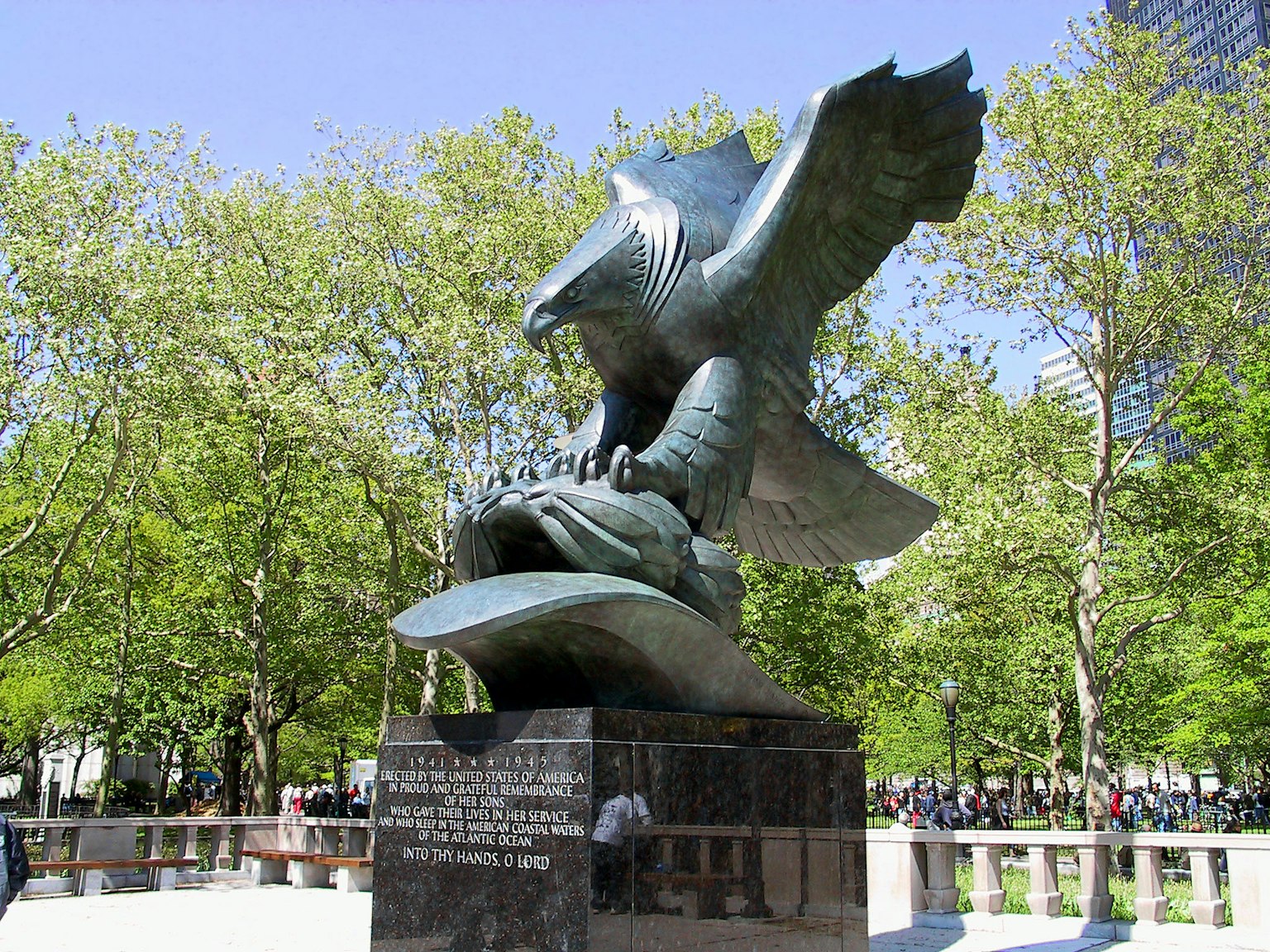 Une grande sculpture d'aigle saisissant un poisson sous un ciel bleu clair