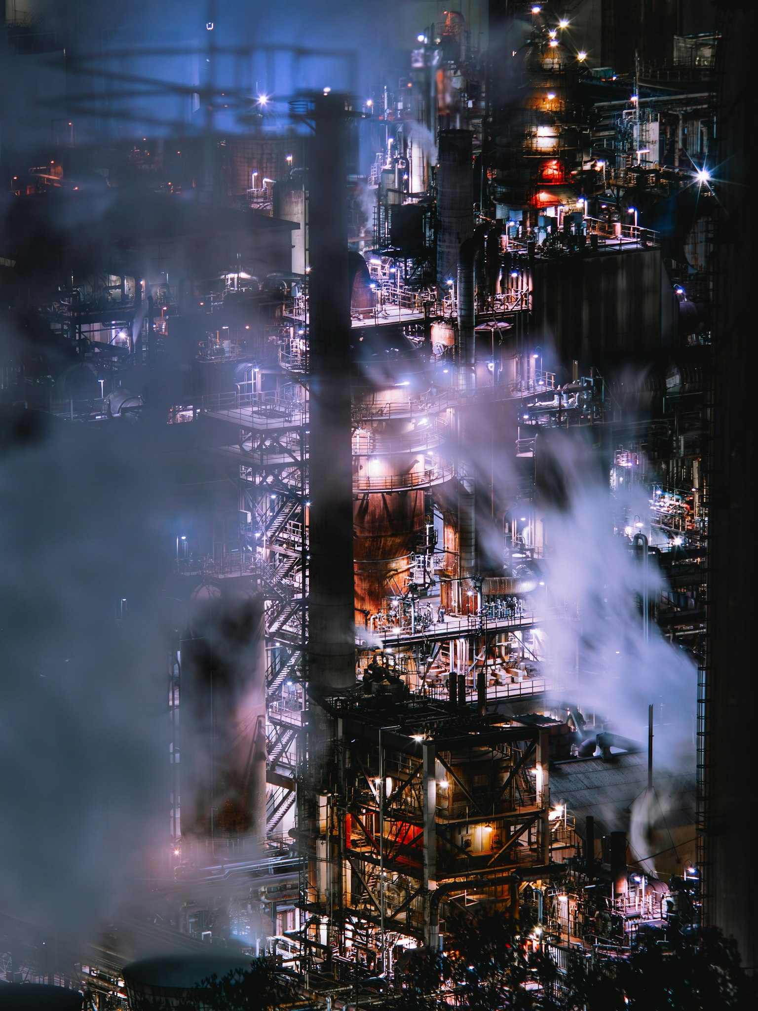 工業プラントの夜景 煙と光が交錯する