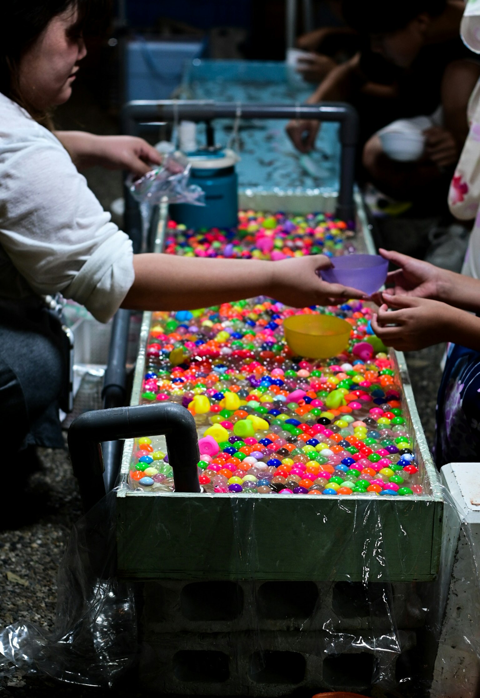 Niños jugando con cuentas coloridas en un tanque de agua