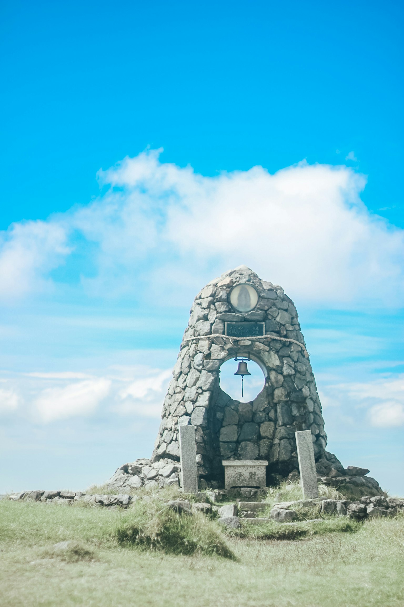 Stone monument with a clock under a blue sky