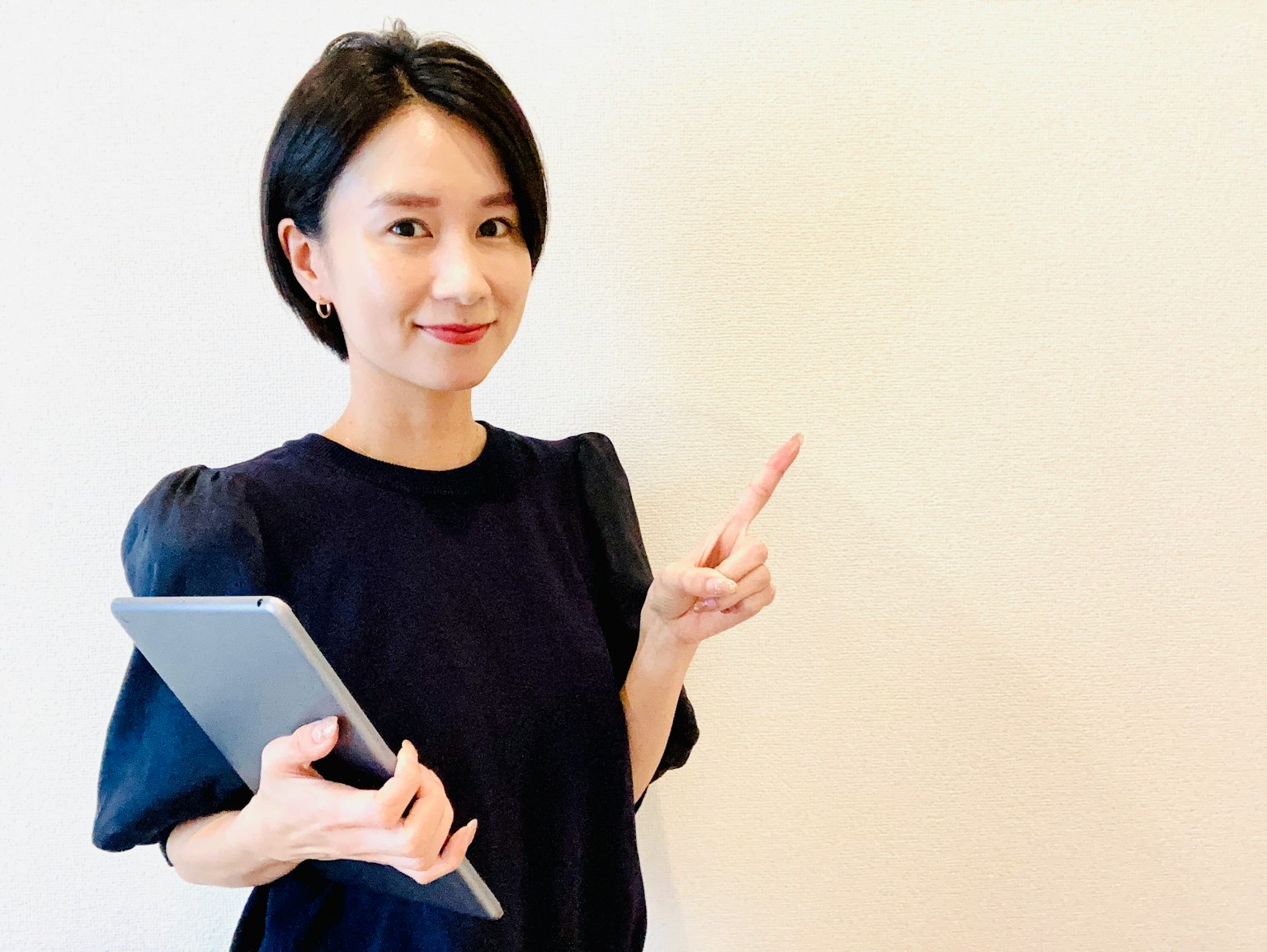 女性手持平板电脑并指向