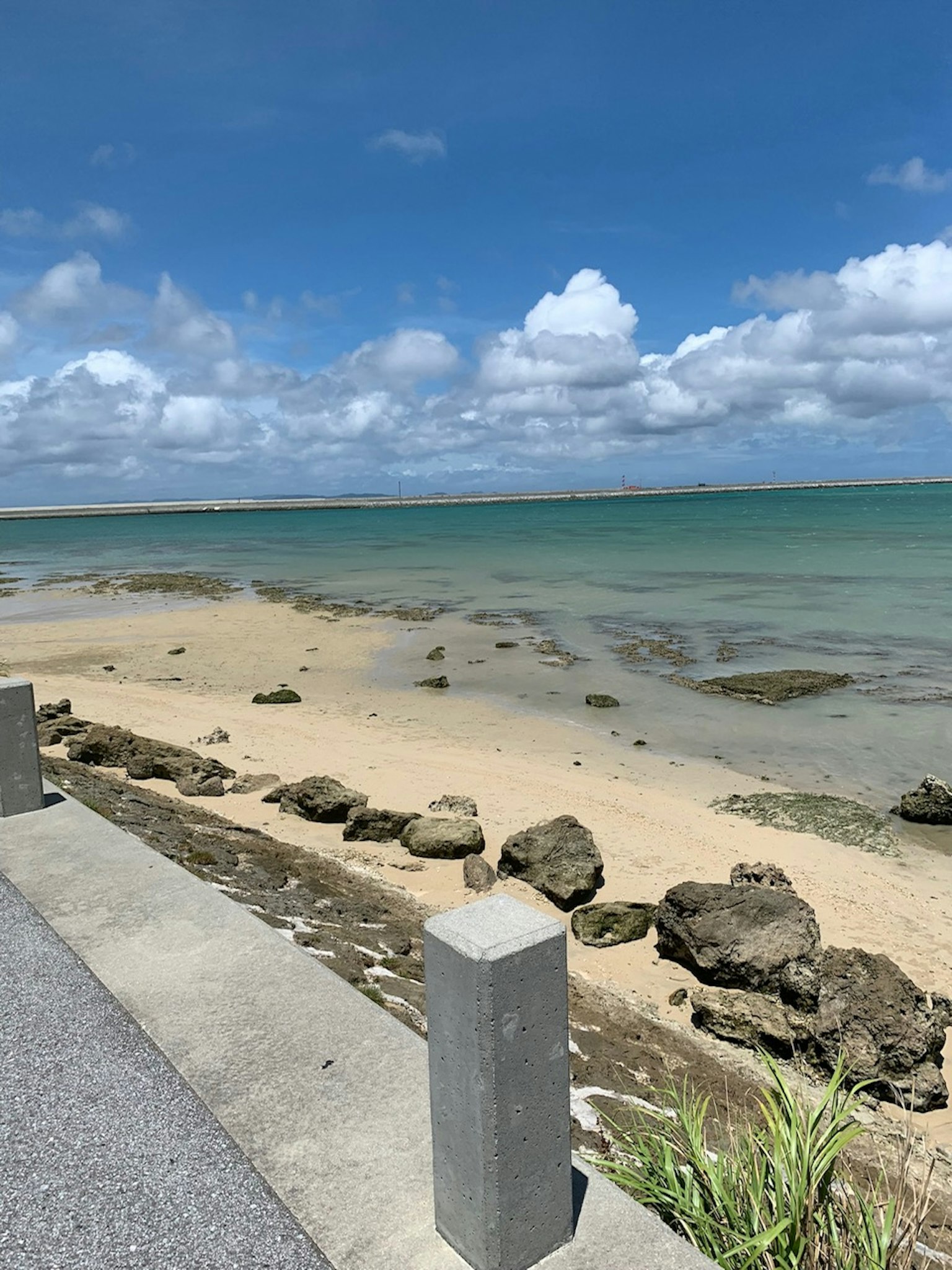 Paesaggio di spiaggia con mare blu e nuvole bianche con rocce e sabbia