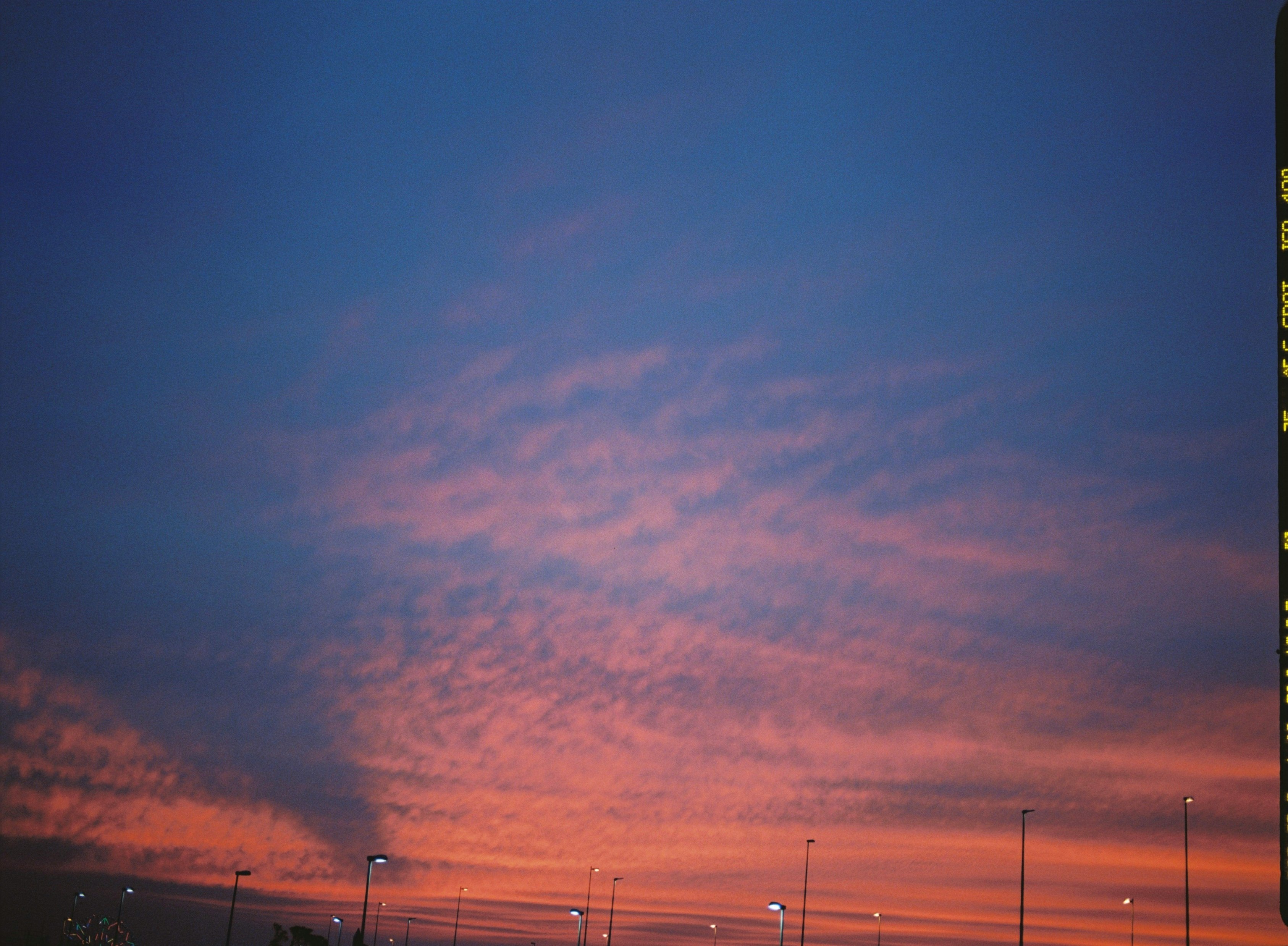 夕焼けの空と街灯が並ぶ広い空の風景