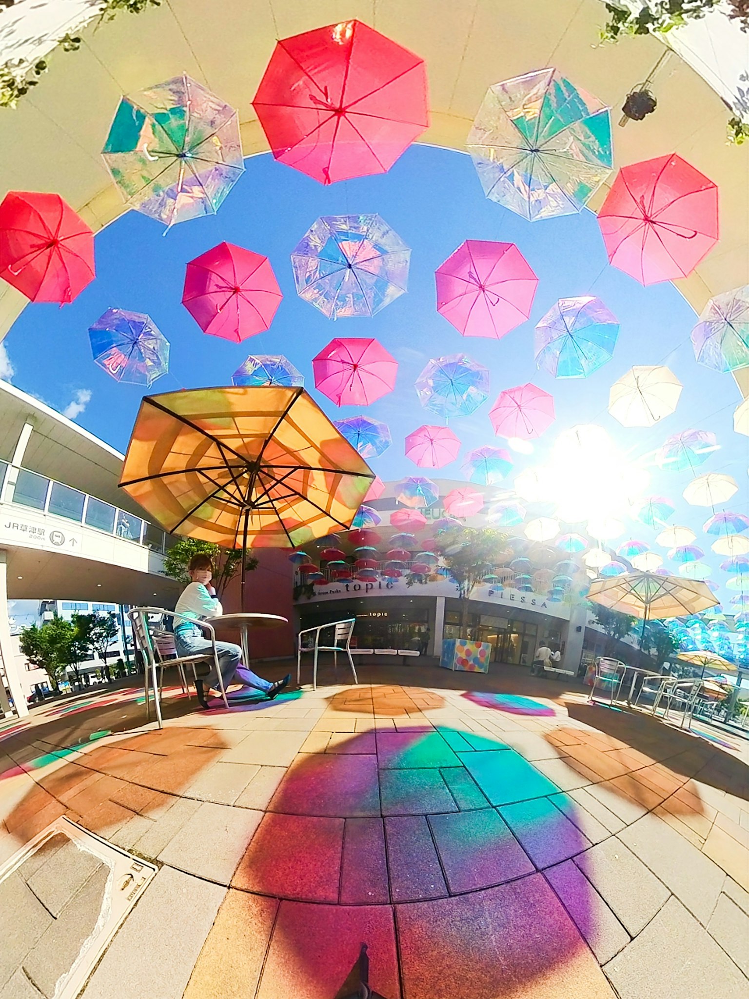 Ombrelli colorati sospesi nel cielo su una terrazza di caffè
