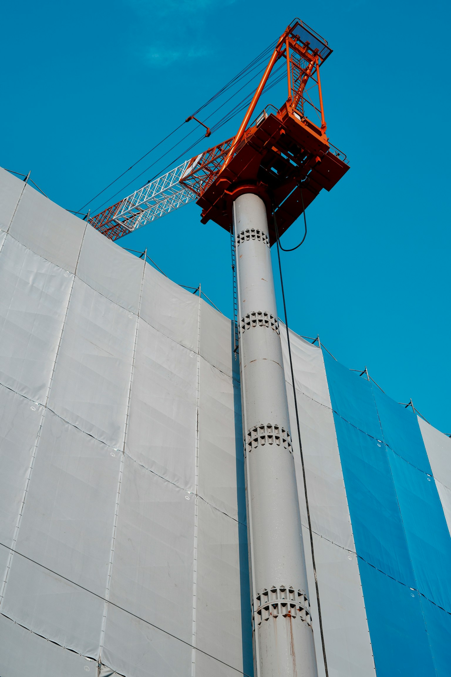 Immagine di una gru da costruzione e di una colonna in cemento in un cantiere di un grattacielo