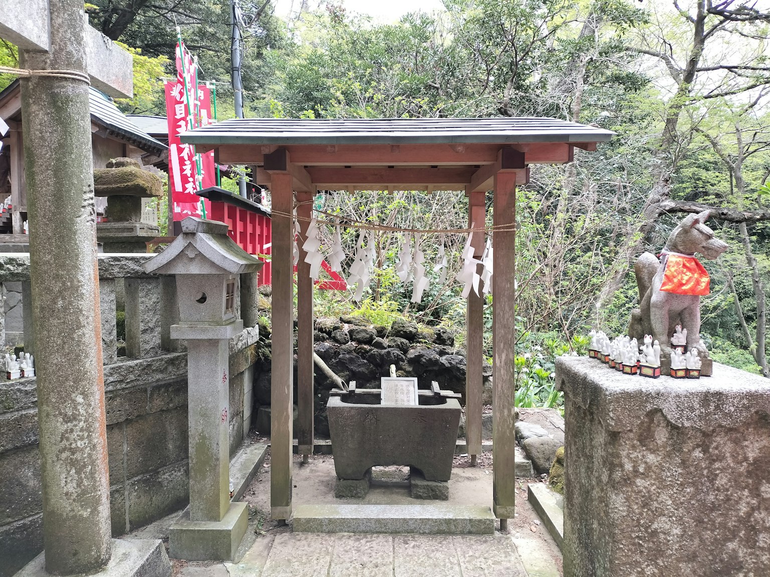 Vue d'un sanctuaire avec une zone de purification et une statue en pierre
