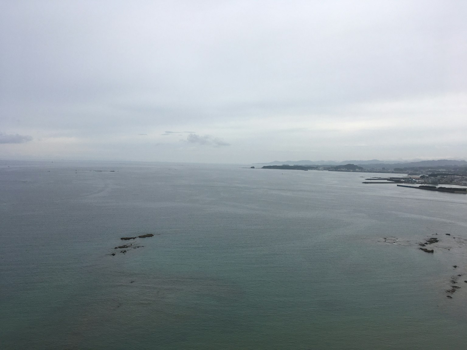 Ciel nuageux au-dessus d'une mer calme et d'une côte lointaine