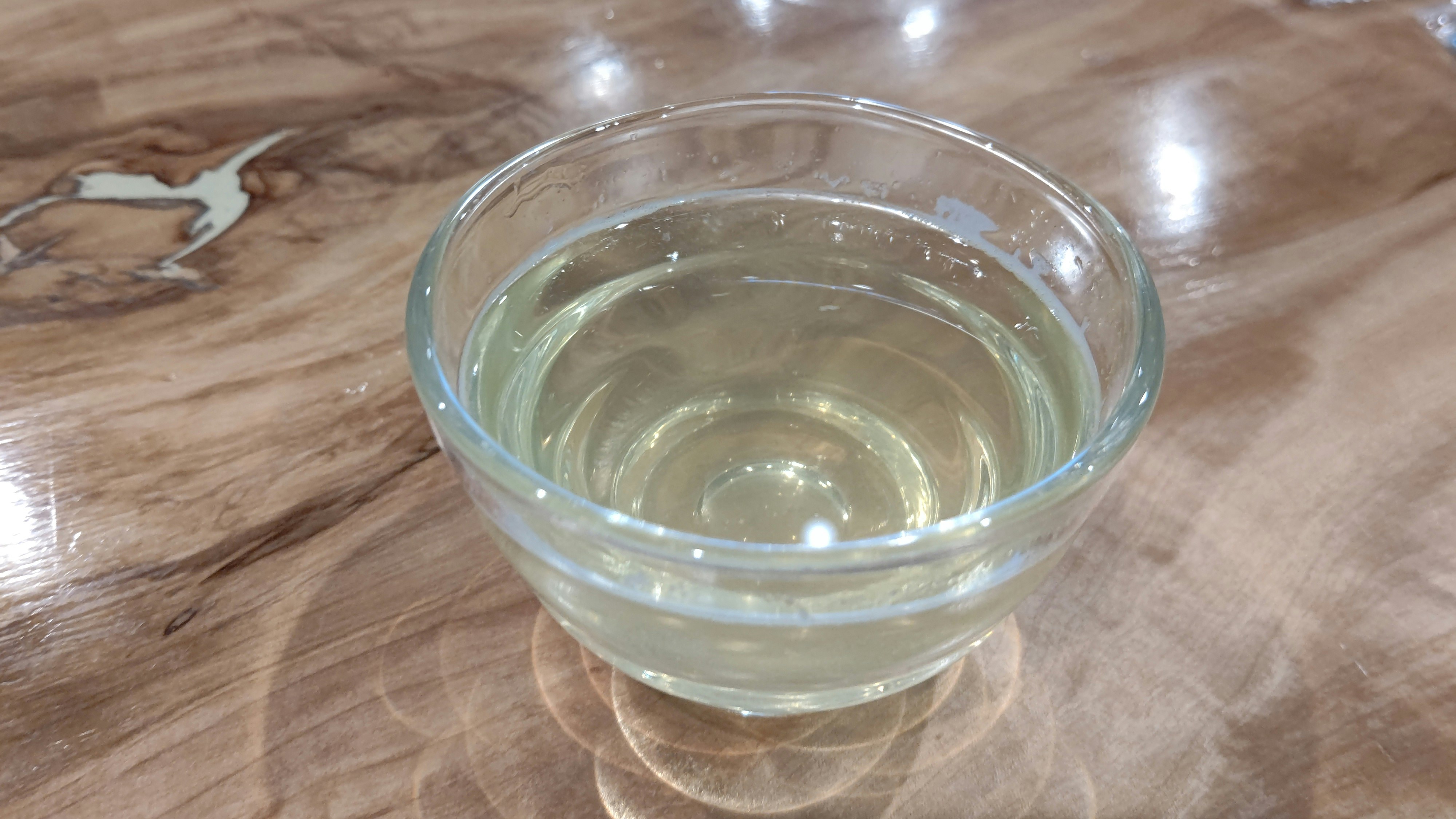 A small clear cup filled with water-like liquid