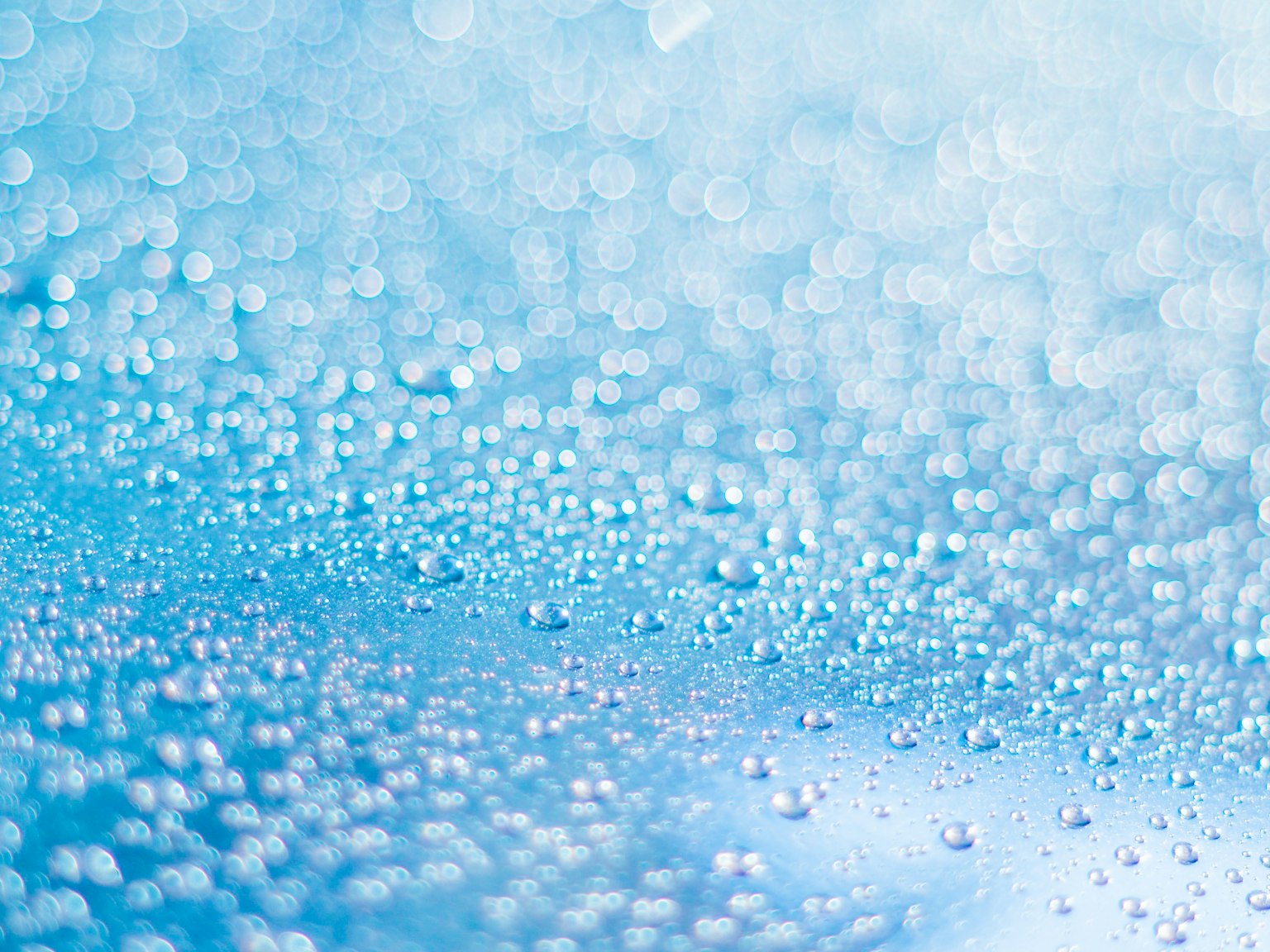 Image vibrante de gouttes d'eau éparpillées sur un fond bleu