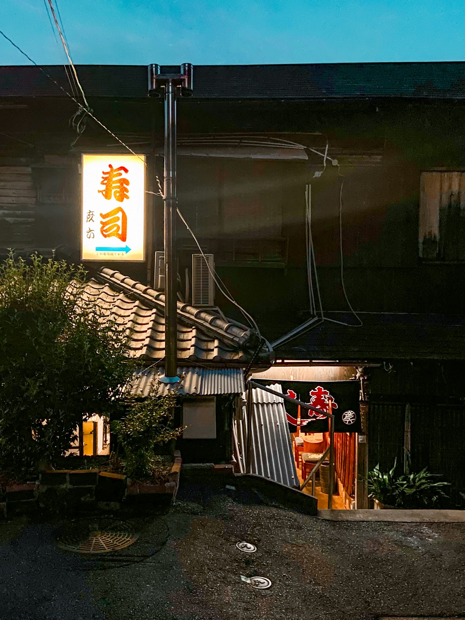 Esterno di un ristorante sushi in una strada buia illuminazione calda crea un'atmosfera accogliente