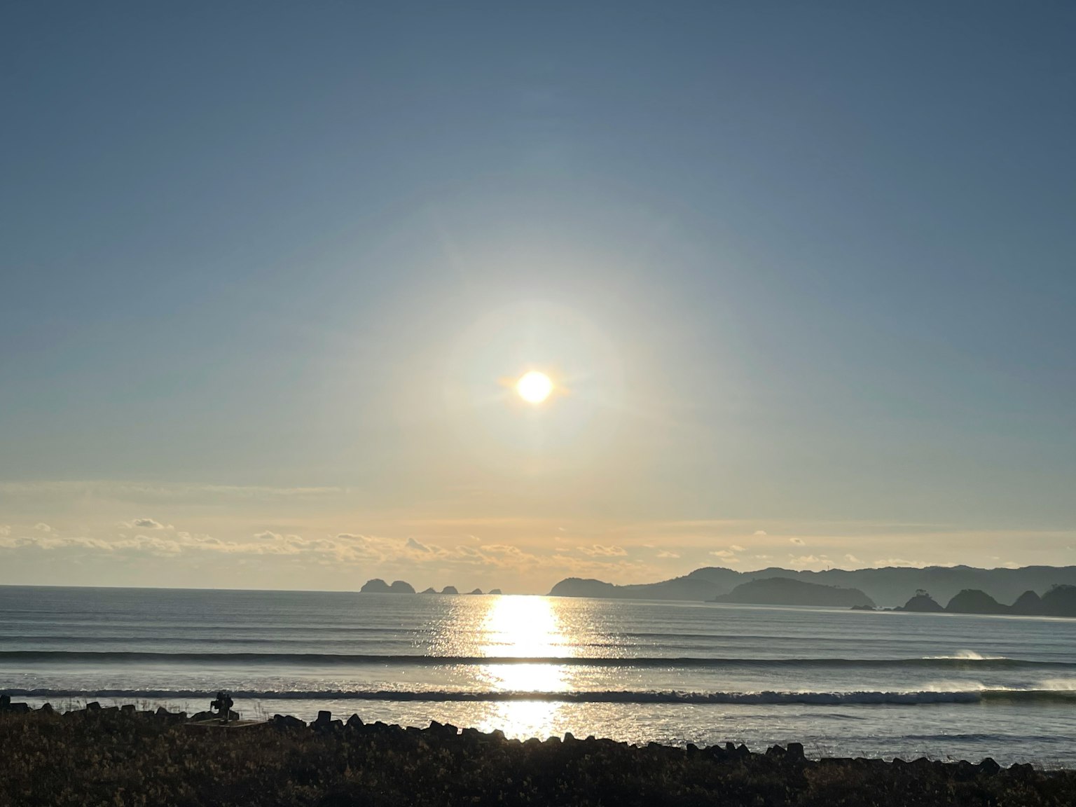 宁静的海岸景观，阳光在平静的海面上反射