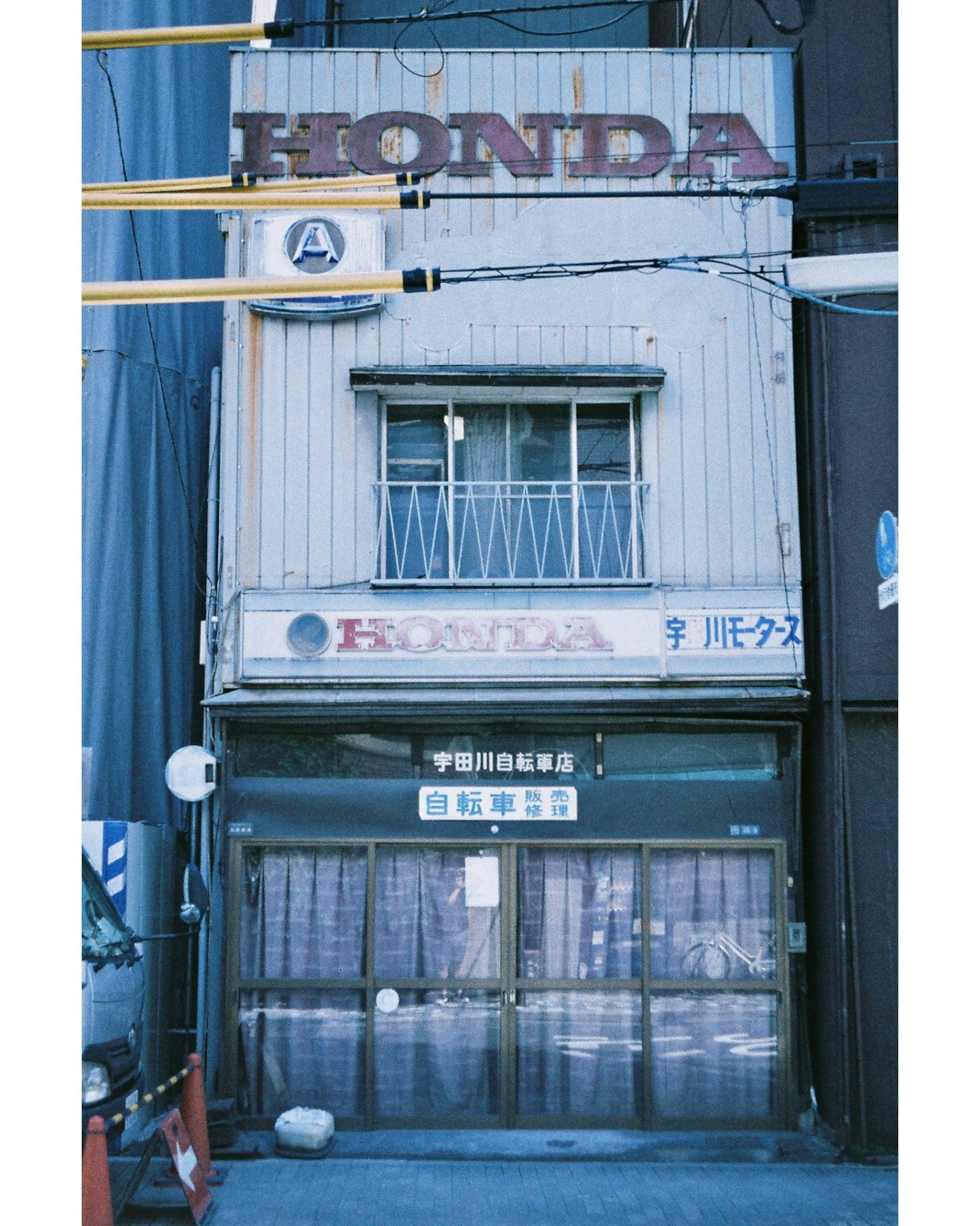 Exterior de una antigua tienda Honda con paredes plateadas y diseño de ventanas