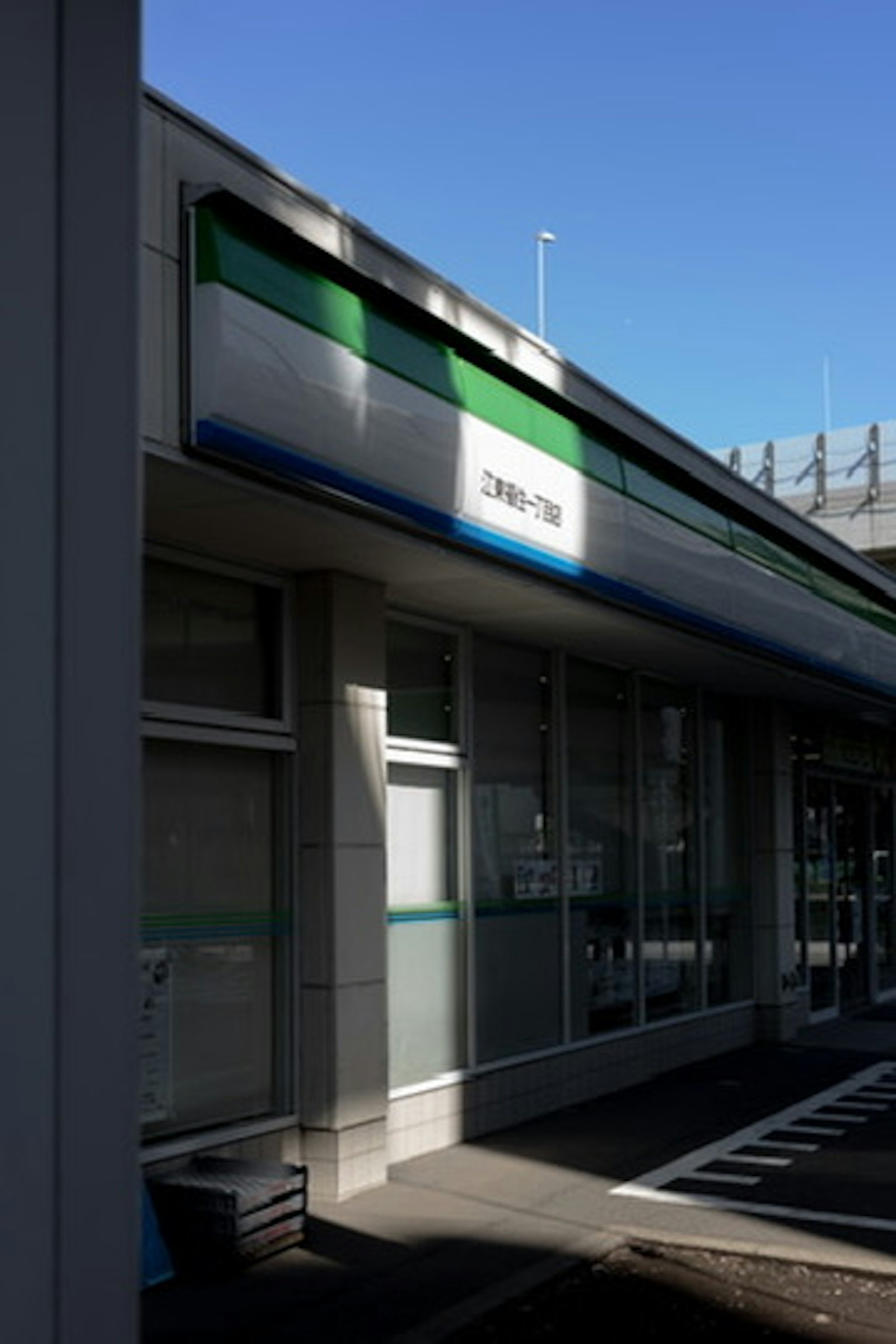 Außenansicht eines Geschäfts unter einem hellblauen Himmel Schatten vor den Fenstern Unternehmensname auf dem Schild angezeigt