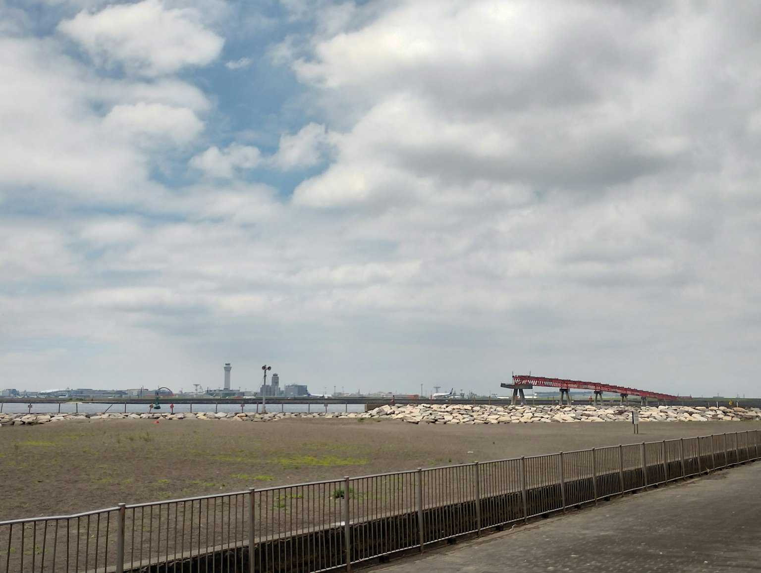 Amplio paisaje con cielo abierto y área industrial al fondo
