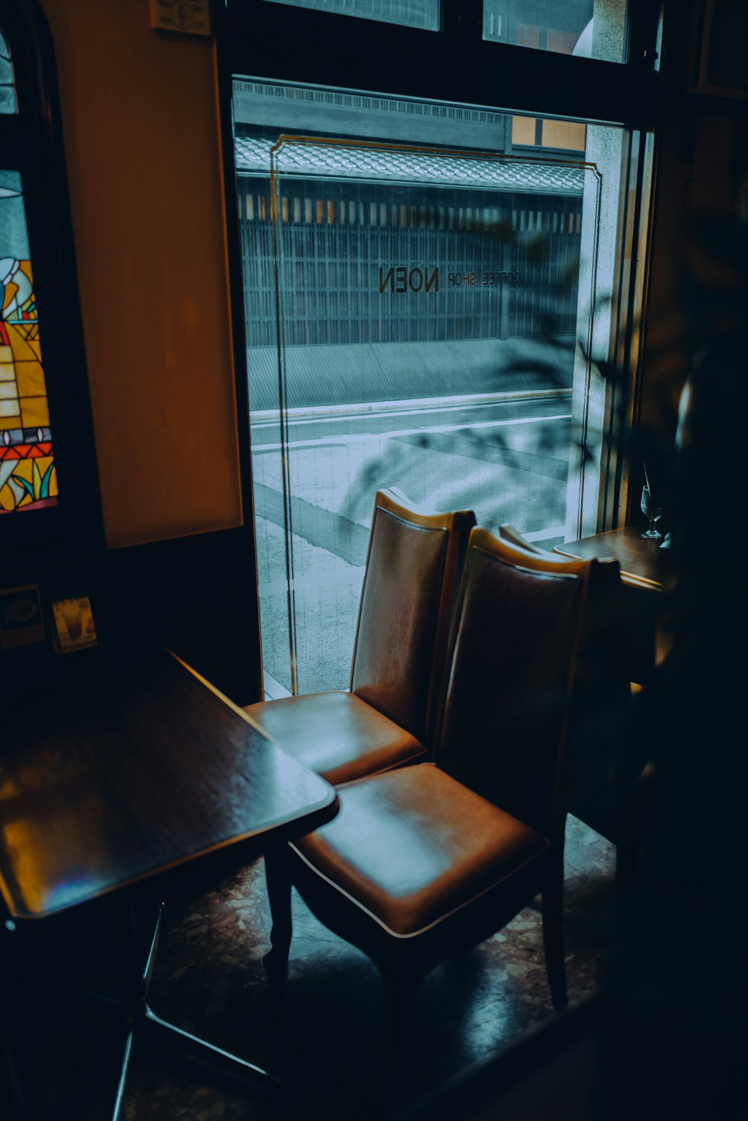 A view of two chairs and a table near a cafe window