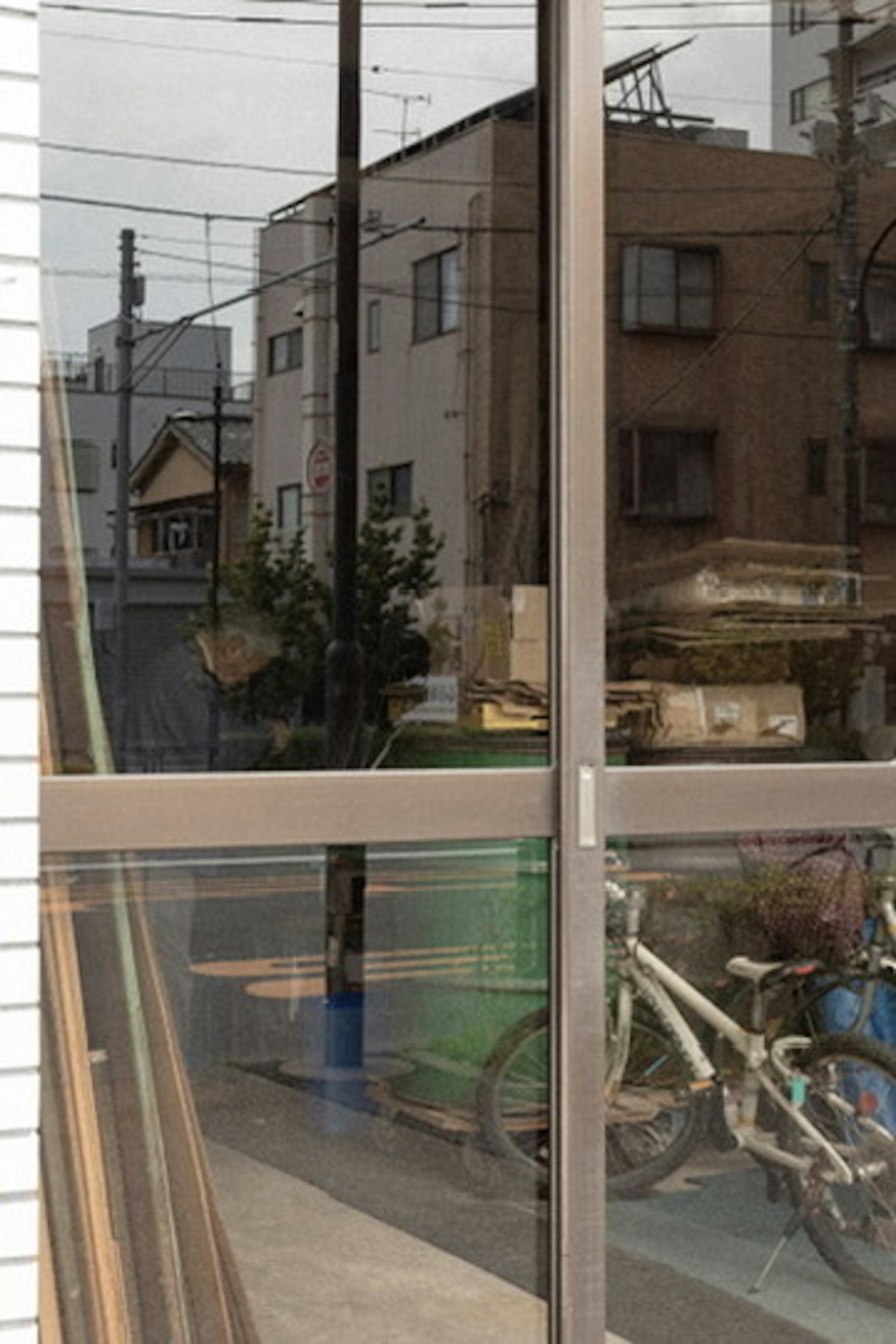 Reflexion einer Stadtlandschaft und eines Fahrrads im Glas