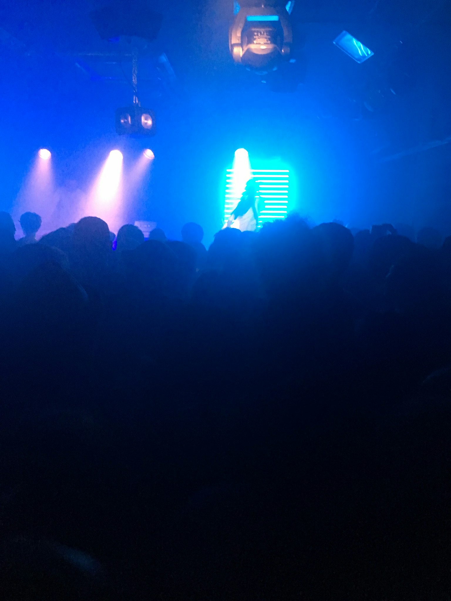 Foule rassemblée dans une scène de club sous un éclairage bleu