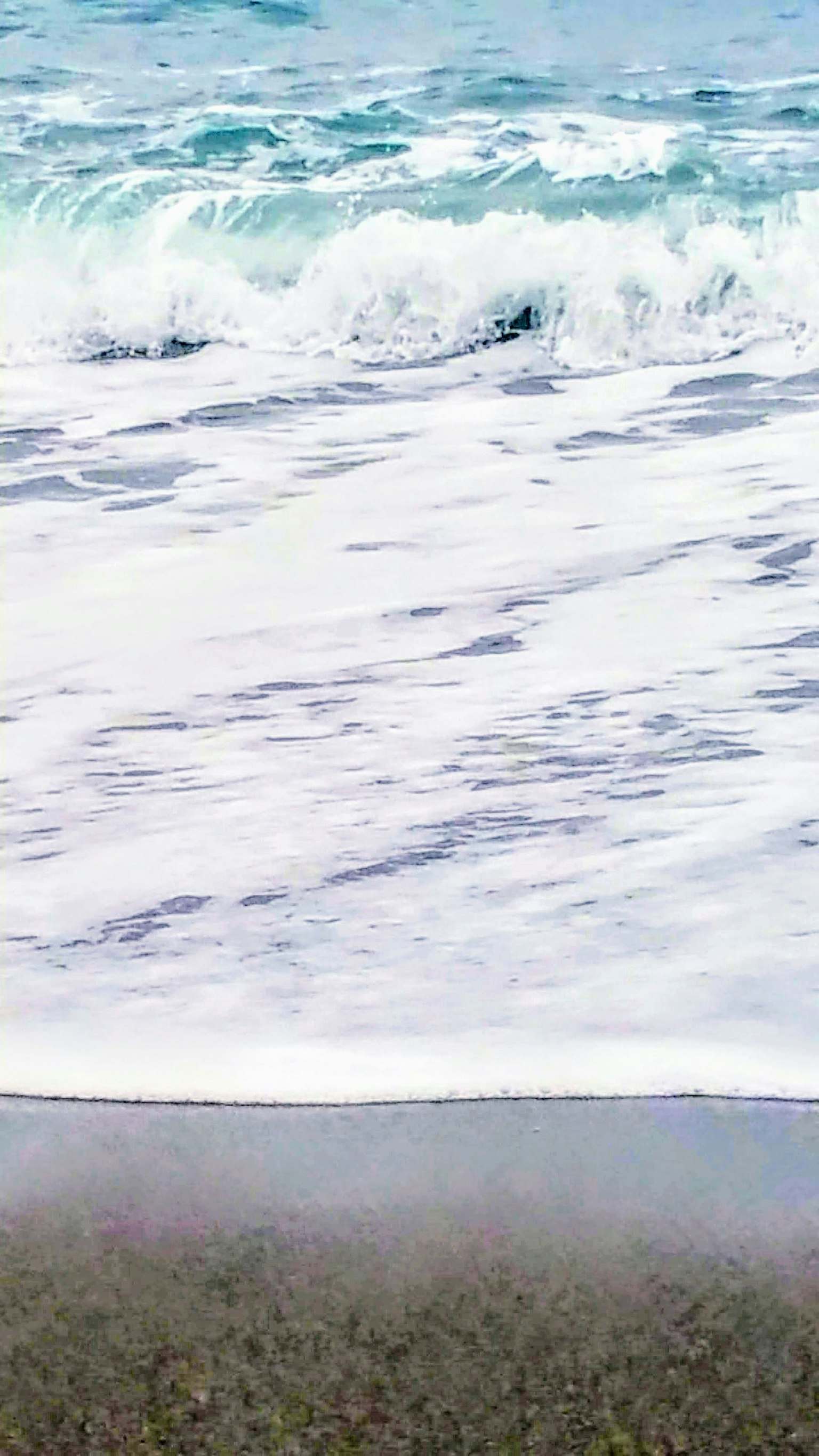 Vagues s'écrasant sur une plage de sable avec de l'eau bleue claire