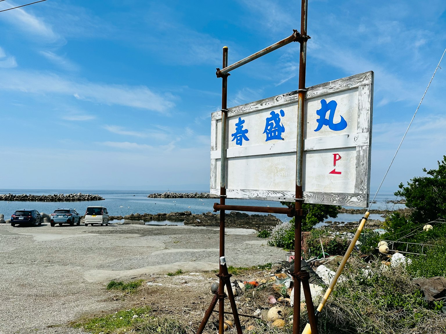 Insegna con lettere blu vicino alla spiaggia e cielo blu sullo sfondo