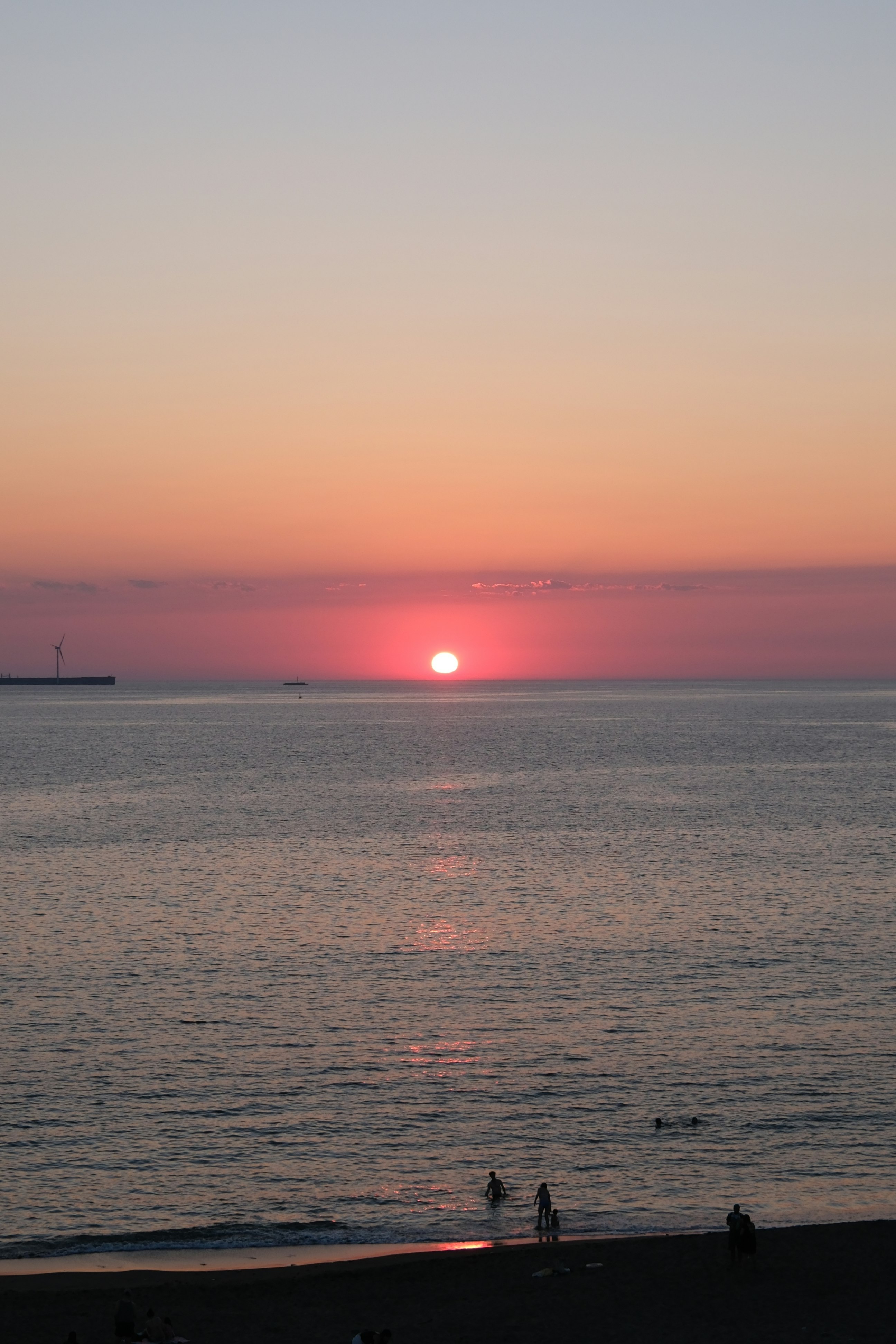 水平線に沈む夕日と海面の反射