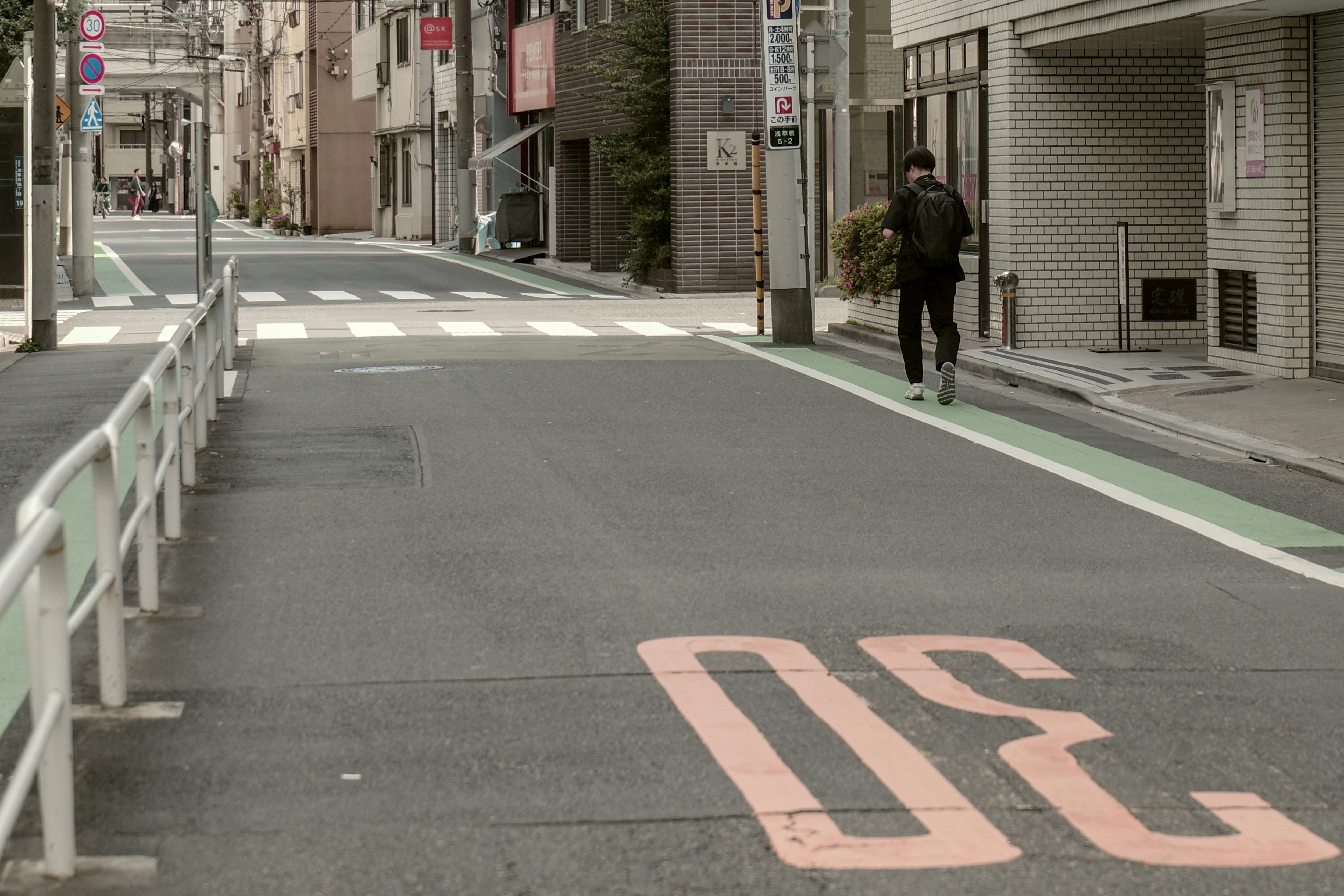 浅草橋の路地を歩く後ろ姿の人物が写る街並み