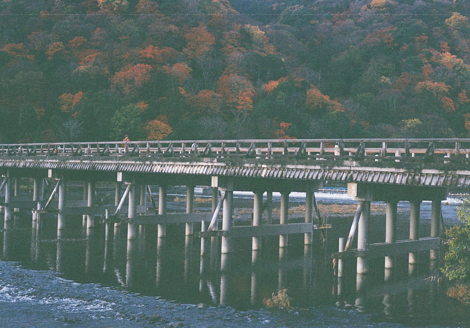 Bridge over a river surrounded by autumn foliage