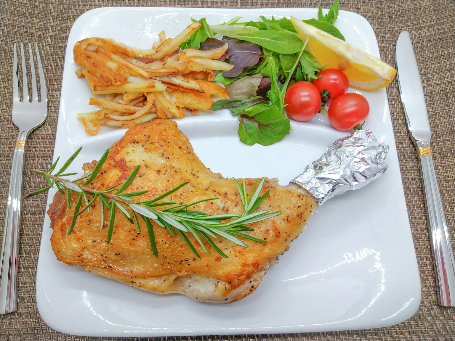ขาไก่ย่างฉ่ำเสิร์ฟพร้อมสลัดและมันฝรั่งอบ