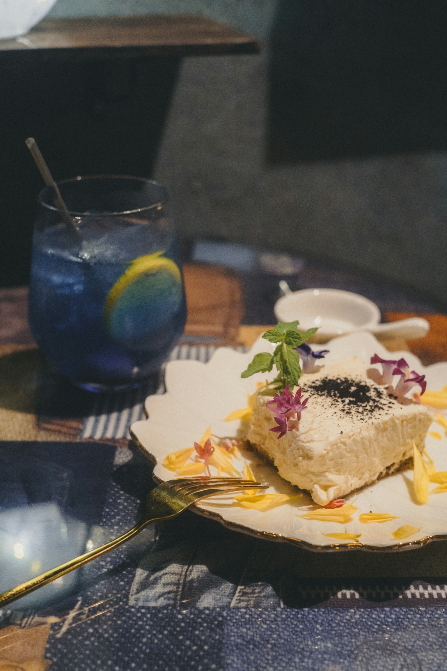 青い飲み物とデザートの皿がテーブルに置かれている
