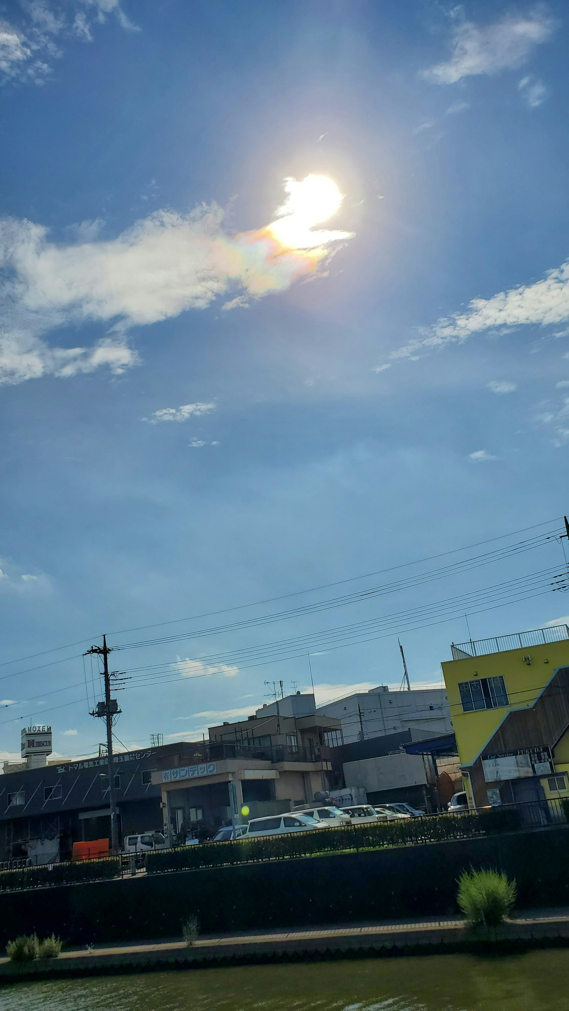 川沿いの工業地帯と青空に浮かぶ太陽の光