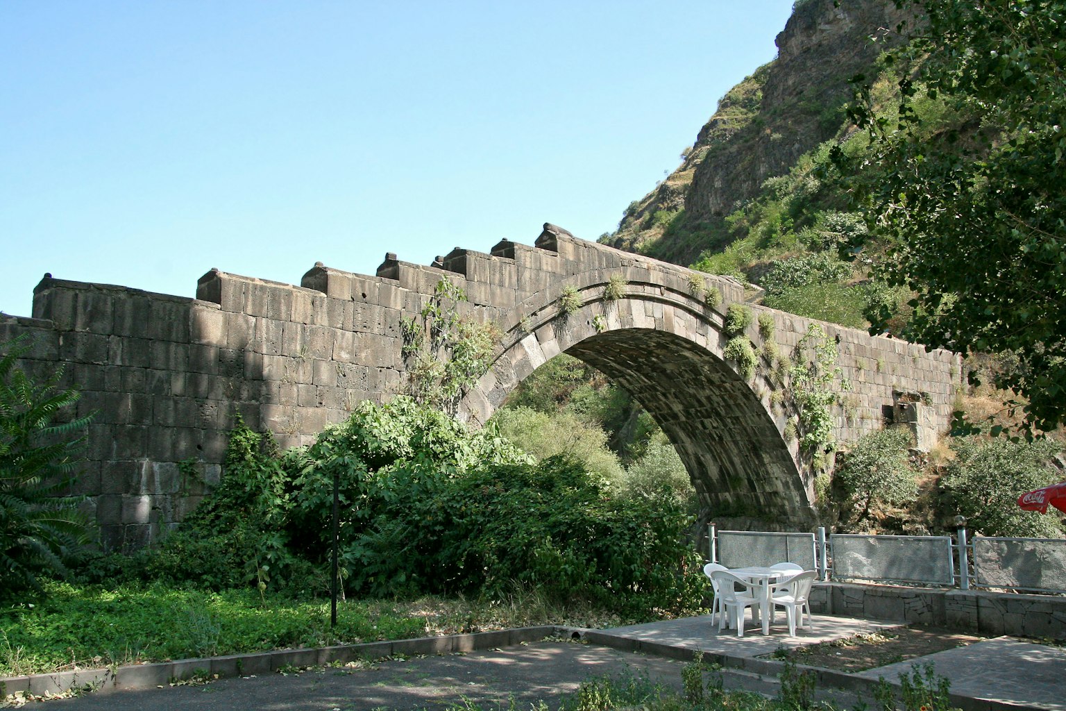 Vieux pont en arc en pierre entouré de verdure luxuriante