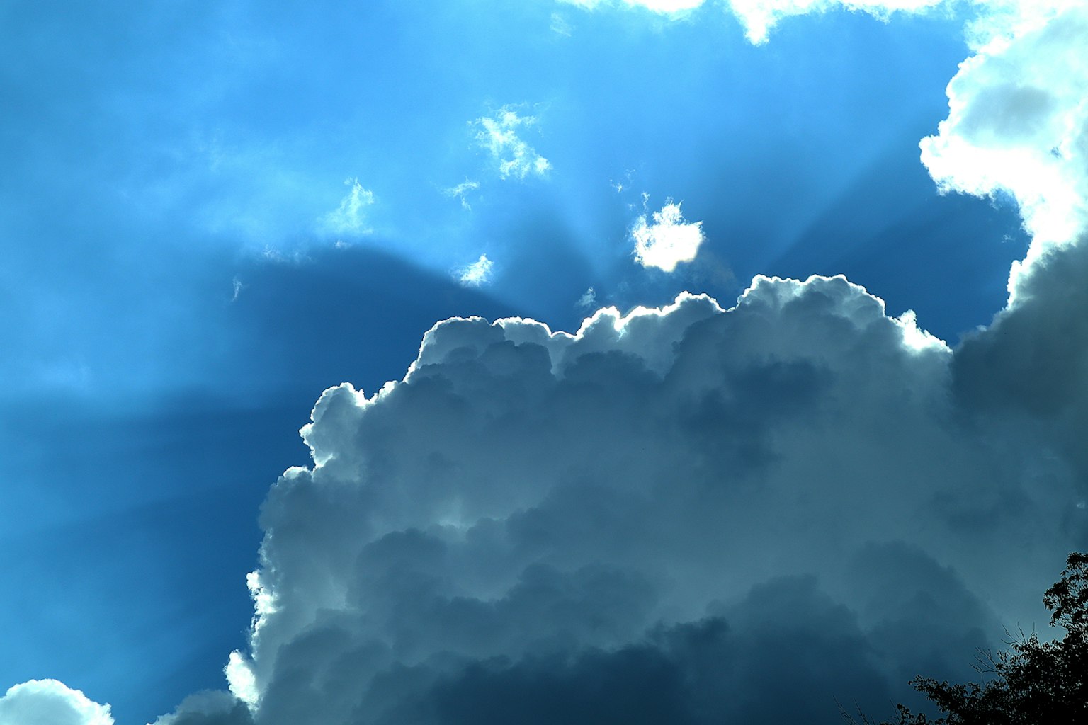 Awan berbulu yang diterangi sinar matahari di latar belakang langit biru