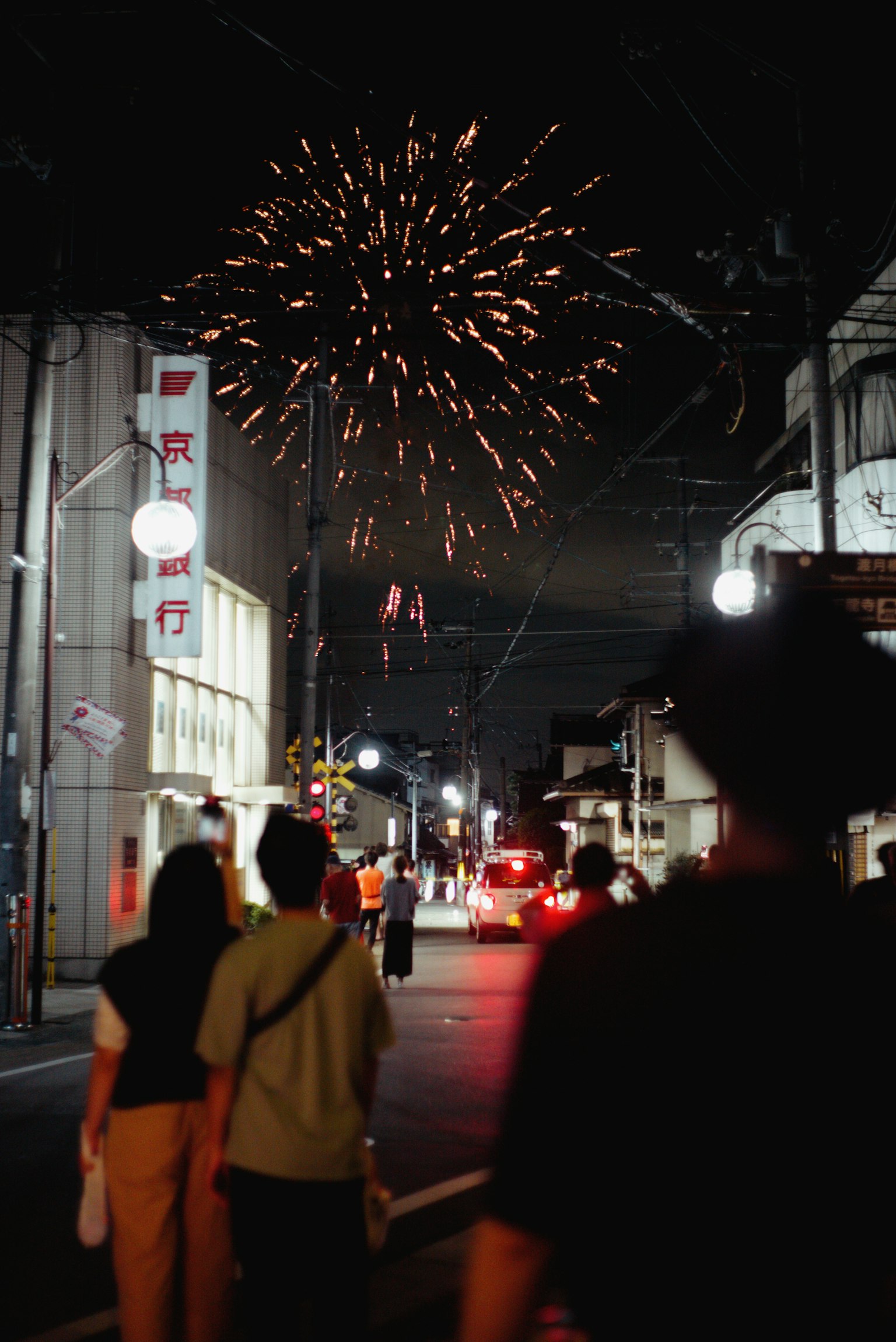 夜空中绽放烟花和街上行走的人们