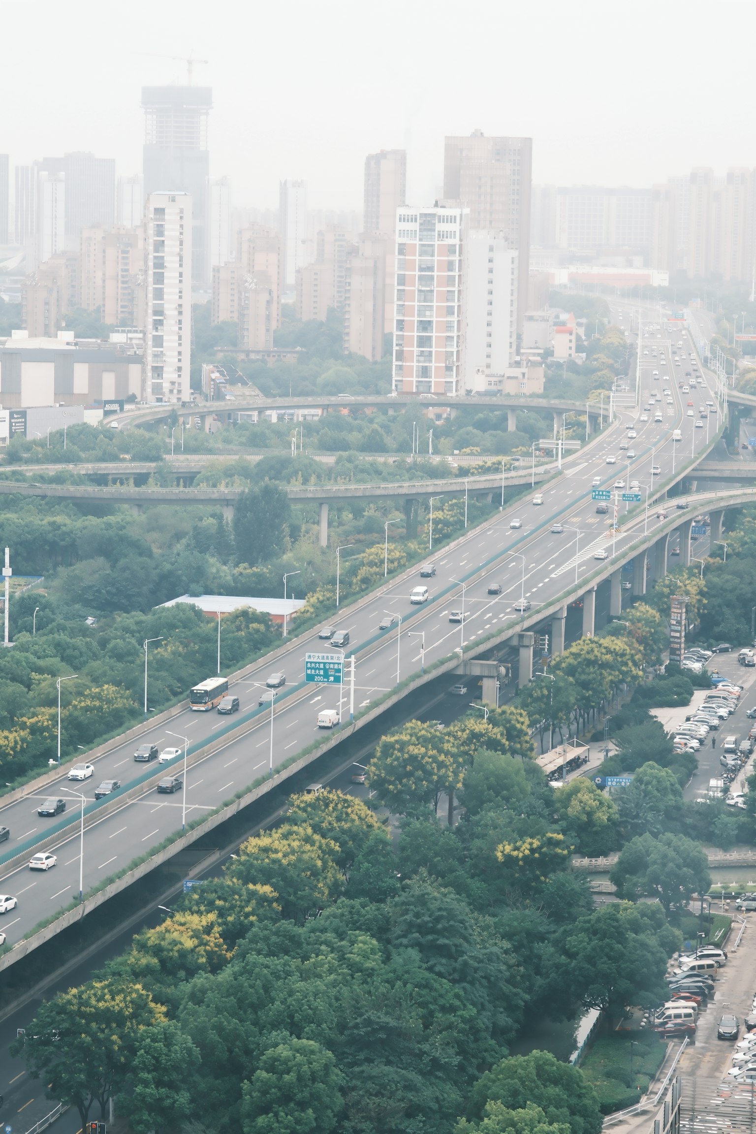 Vista aerea di una città con grattacieli e un paesaggio verde con una strada elevata