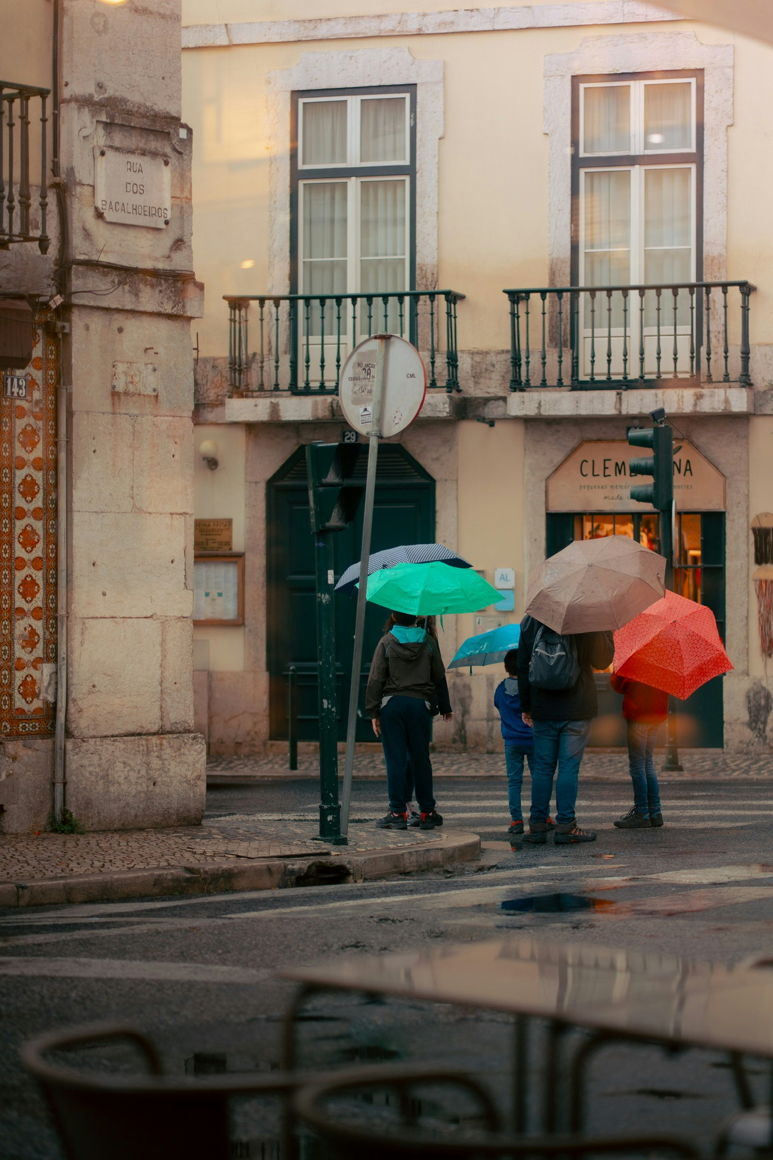 傘を持った人々が街角に立っている風景