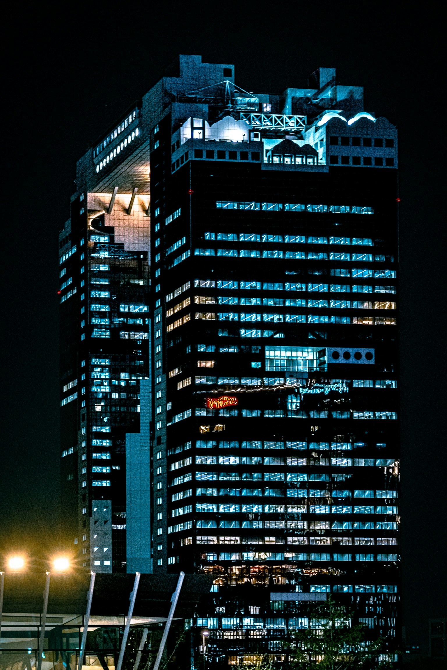 Vista nocturna de un rascacielos moderno iluminado en un entorno urbano