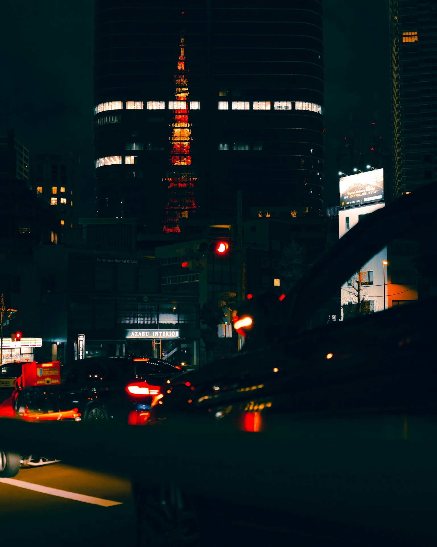 Tokyo Tower ส่องสว่างในเวลากลางคืนพร้อมภูมิทัศน์เมืองสัญญาณไฟจราจรและไฟรถยนต์