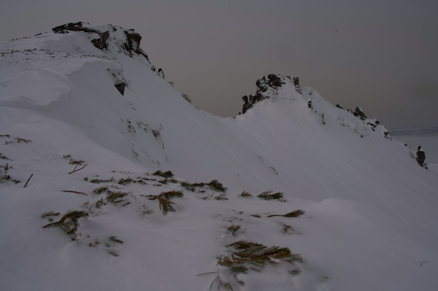 Paisaje montañoso cubierto de nieve con nubes oscuras