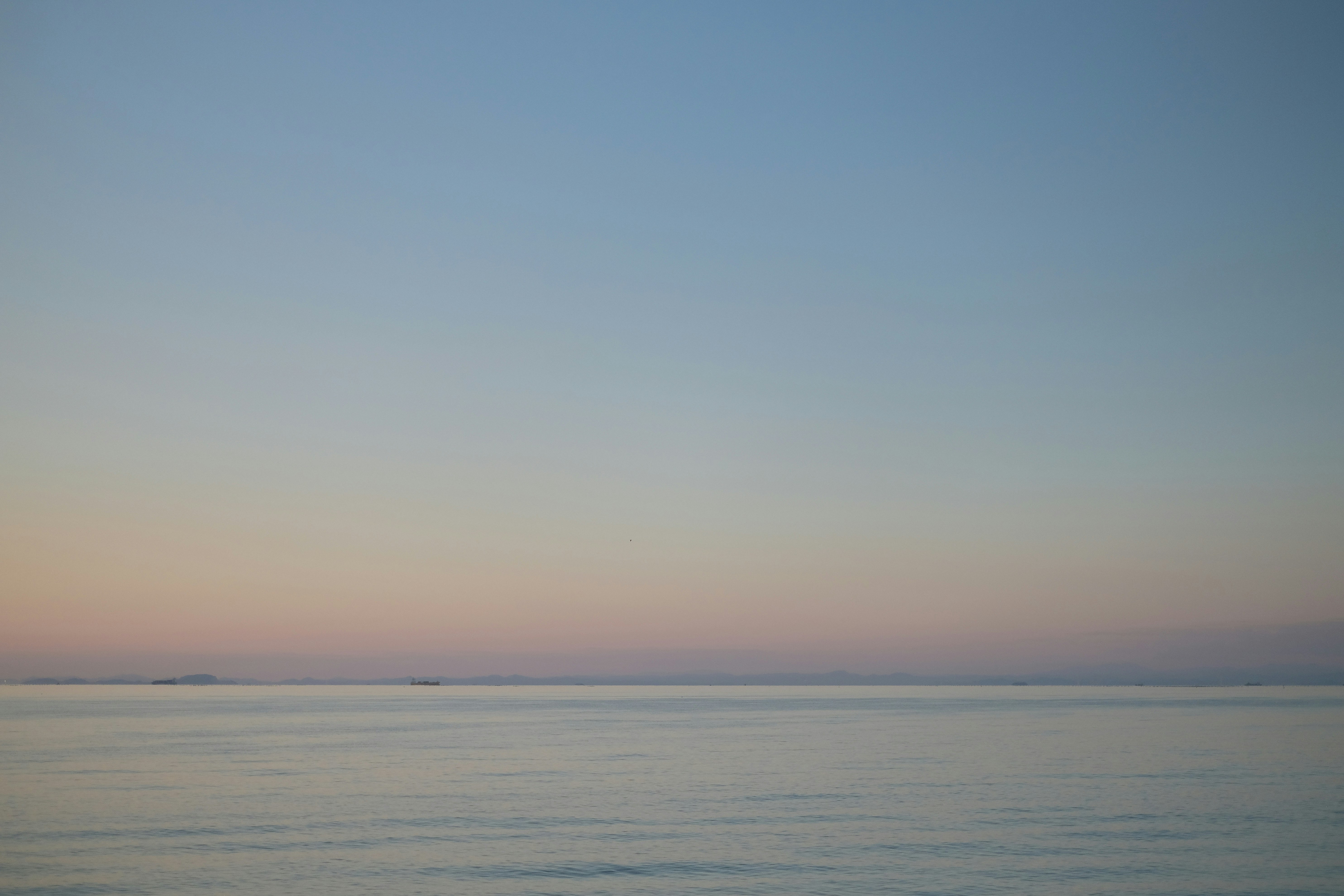 何にもない水平線に沈む夕日と静かな海面