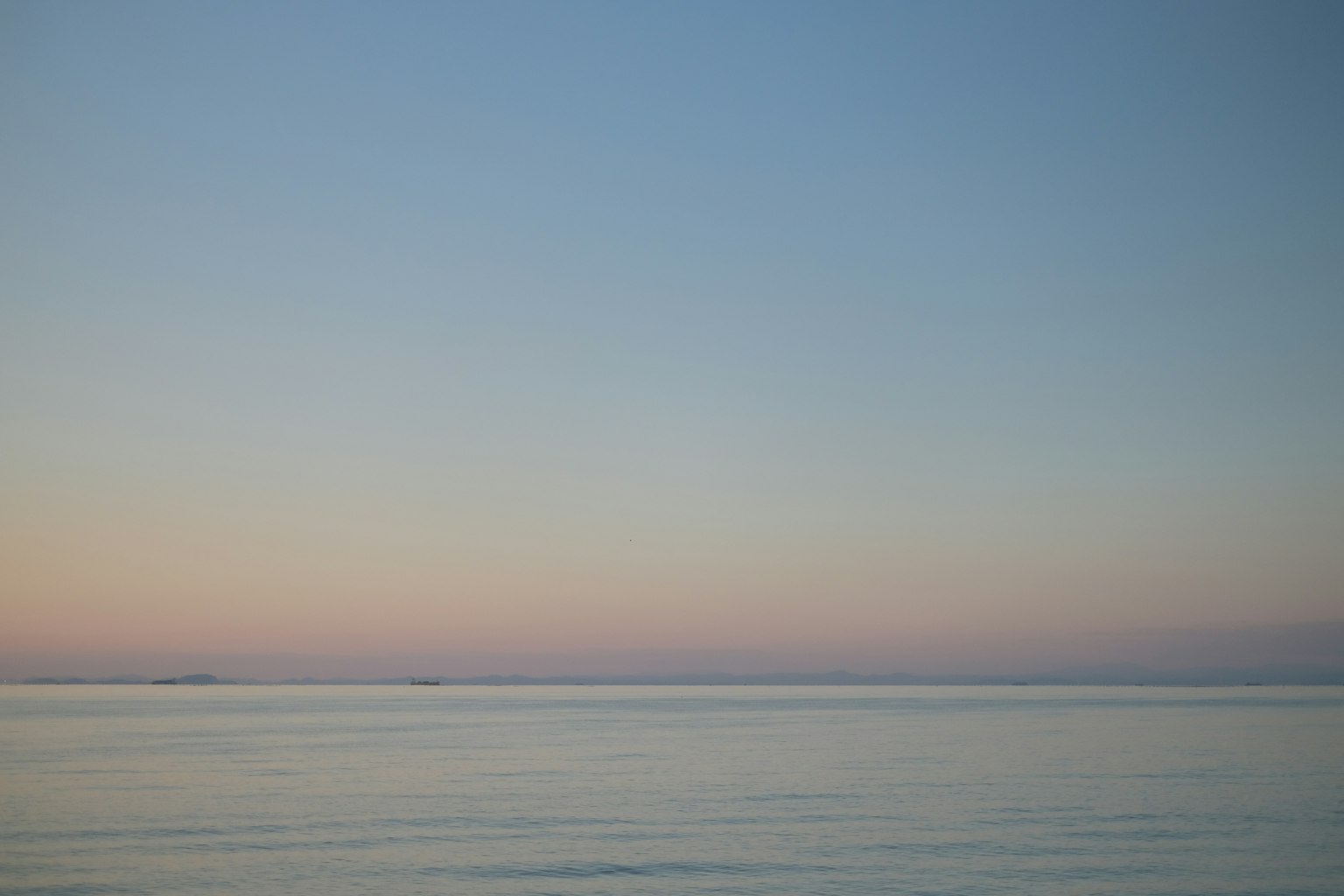 Paesaggio marino sereno con cielo sfumato e acque calme