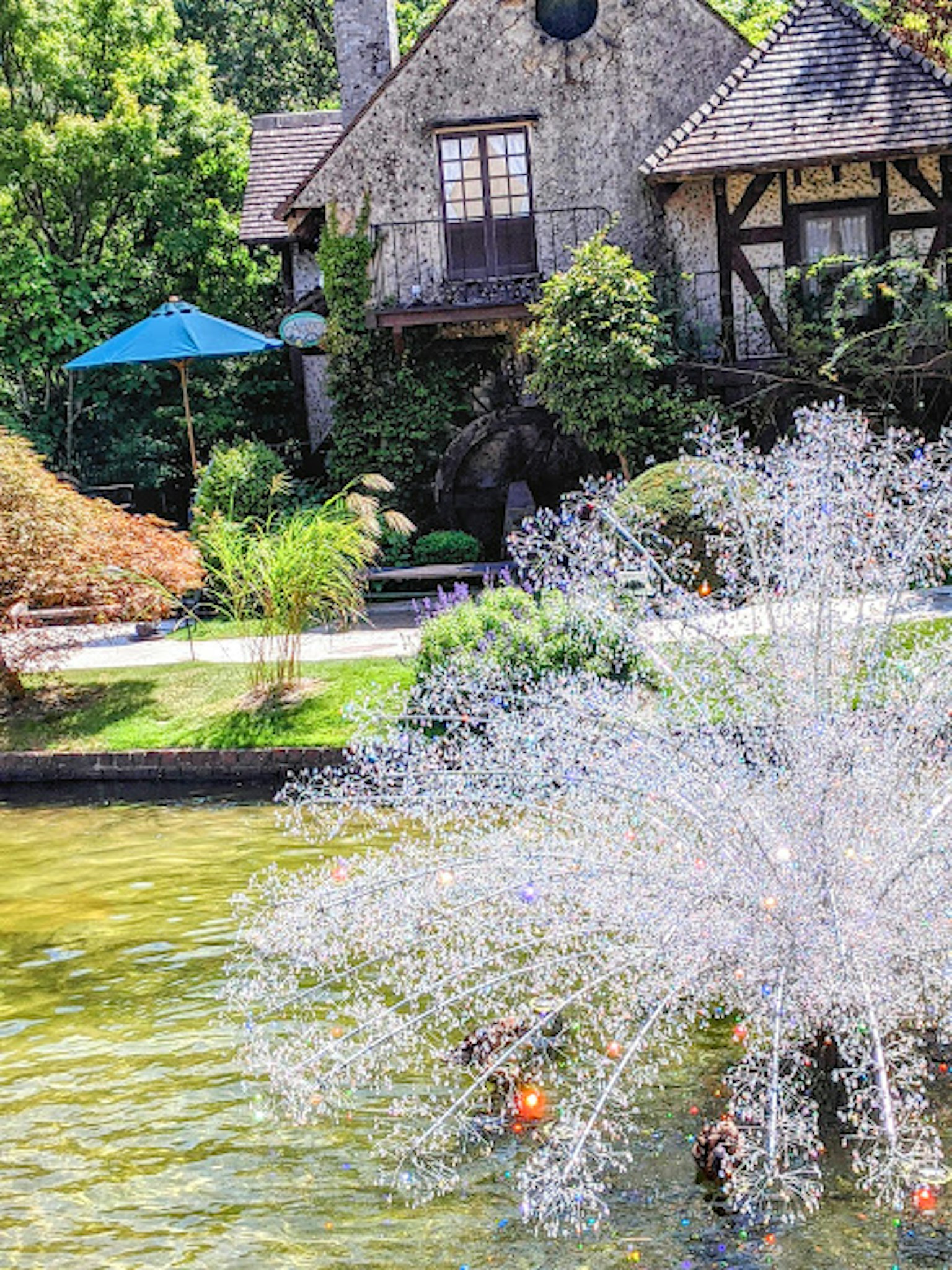 Casa de piedra rodeada de un hermoso jardín y una fuente
