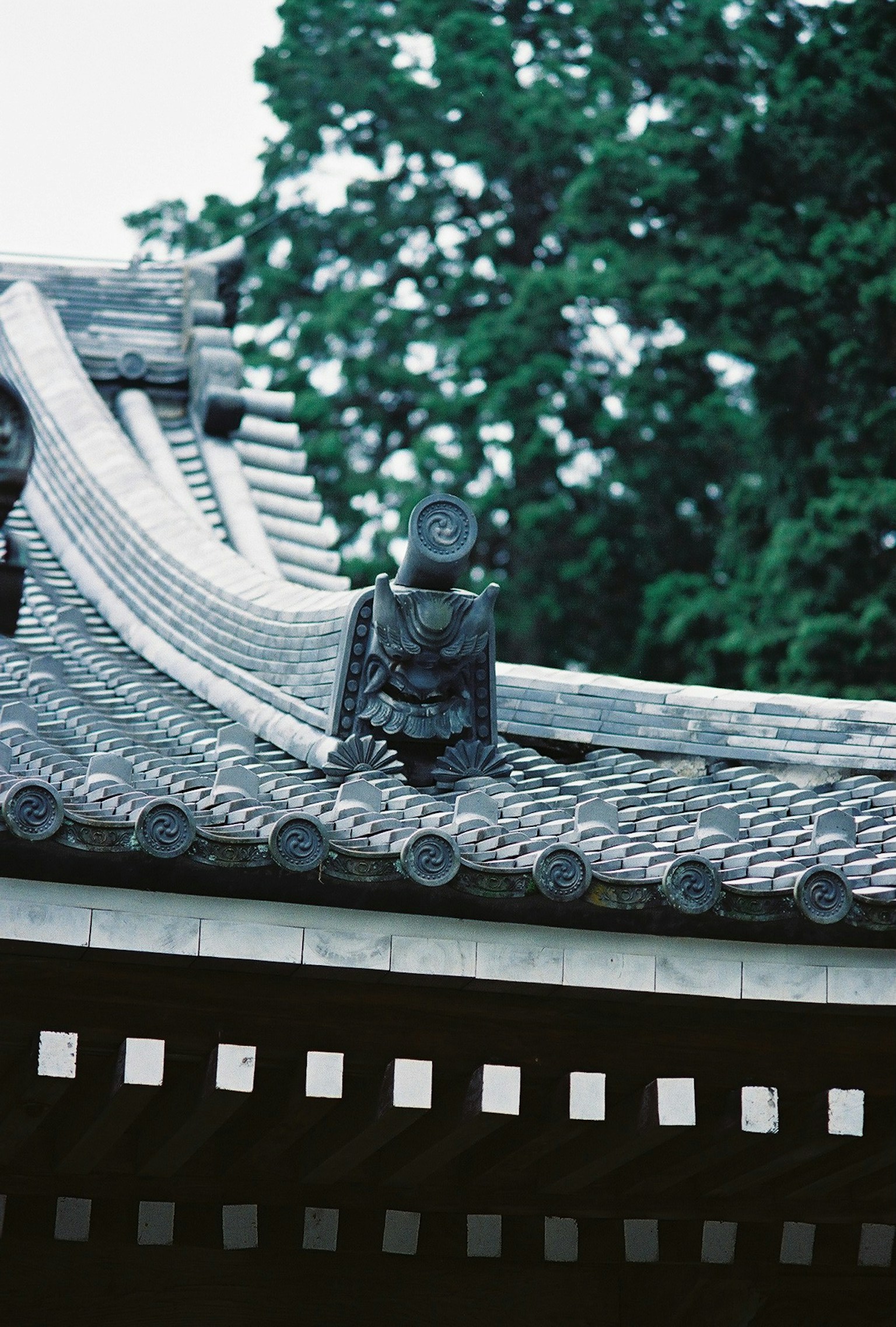 伝統的な日本の屋根の上にある装飾的な彫刻と緑の背景