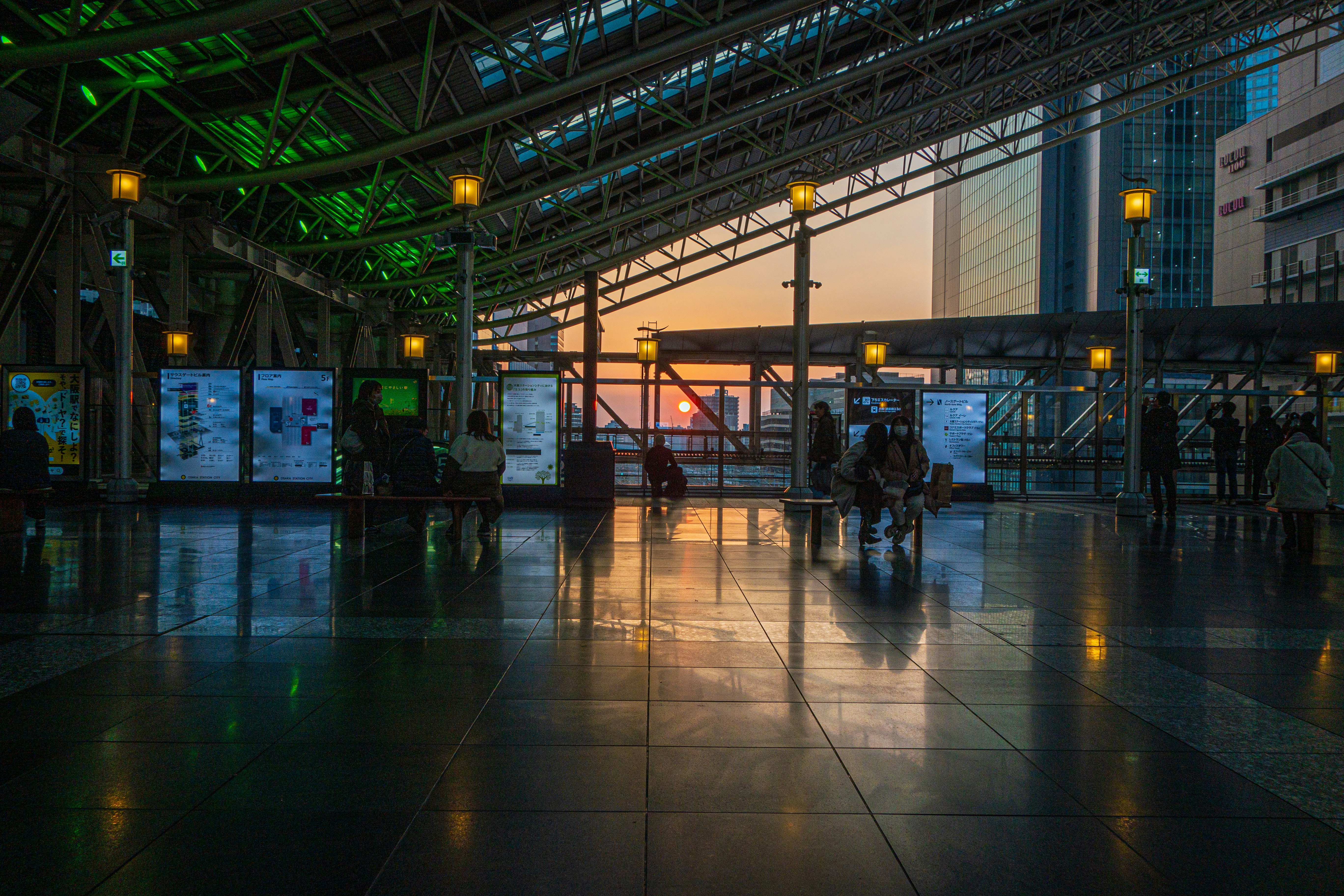 夕日に照らされた駅のホームの広い待合空間
