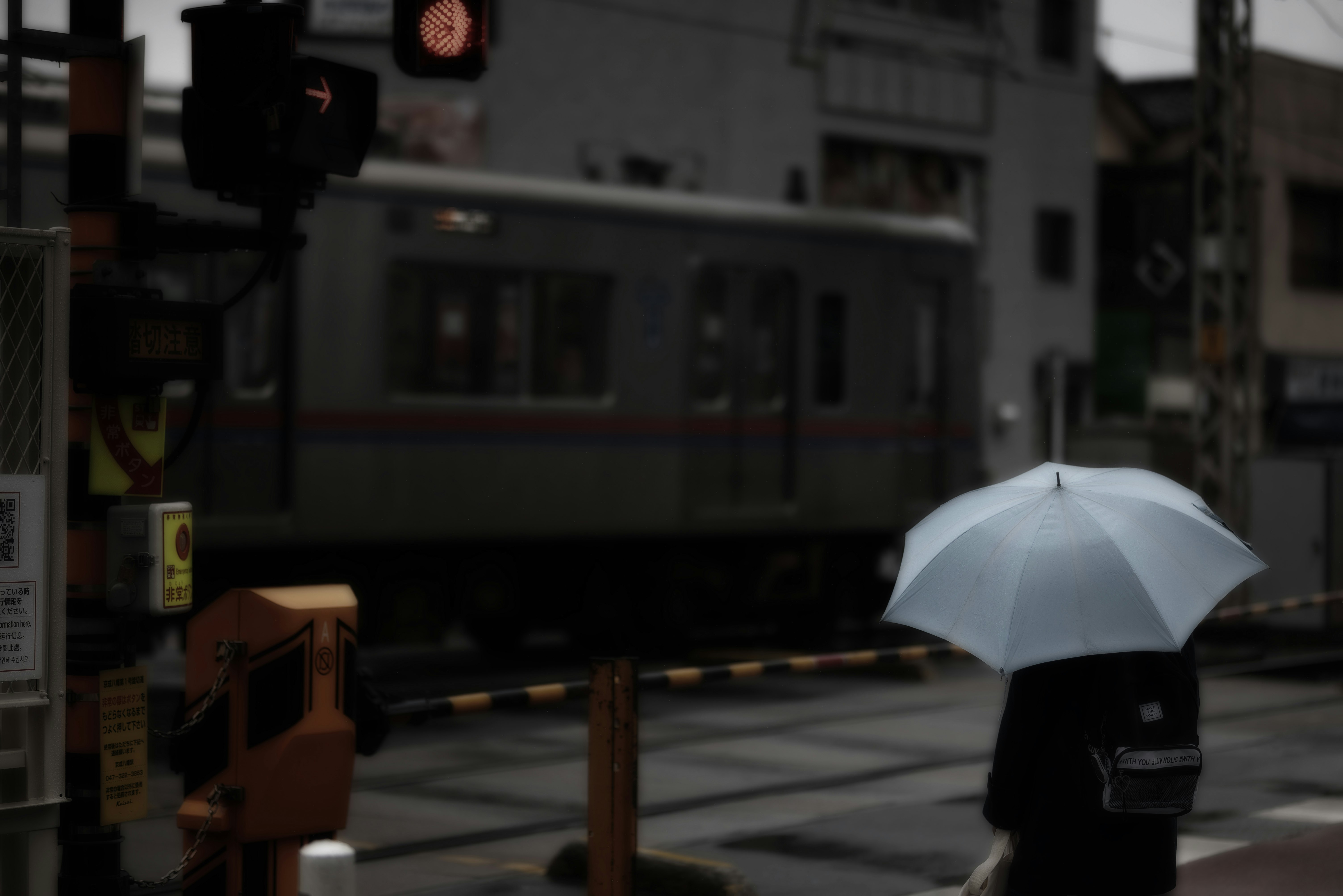 雨の日の傘をさす人と路地の街並み